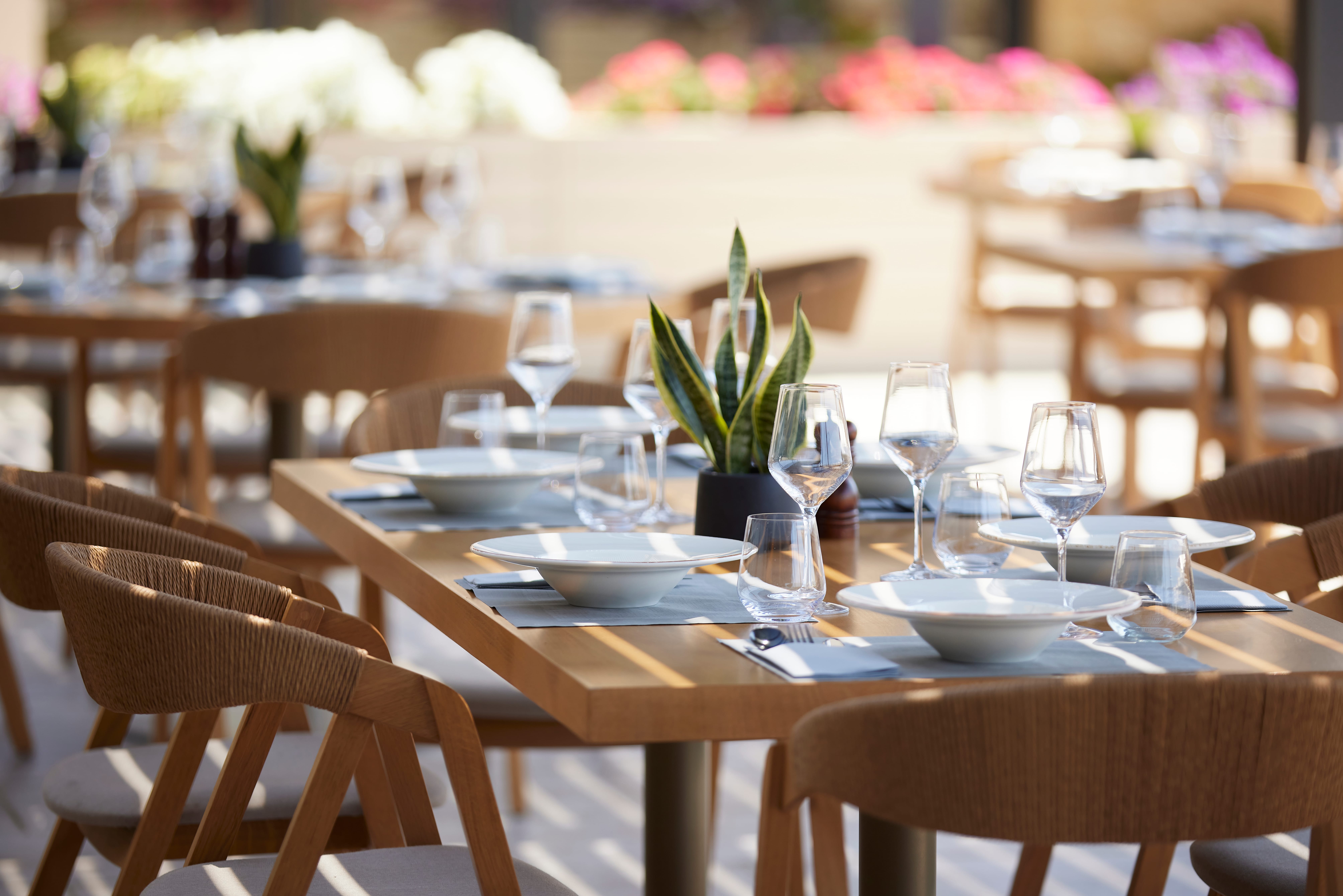 a set of tables with plates and glasses on them