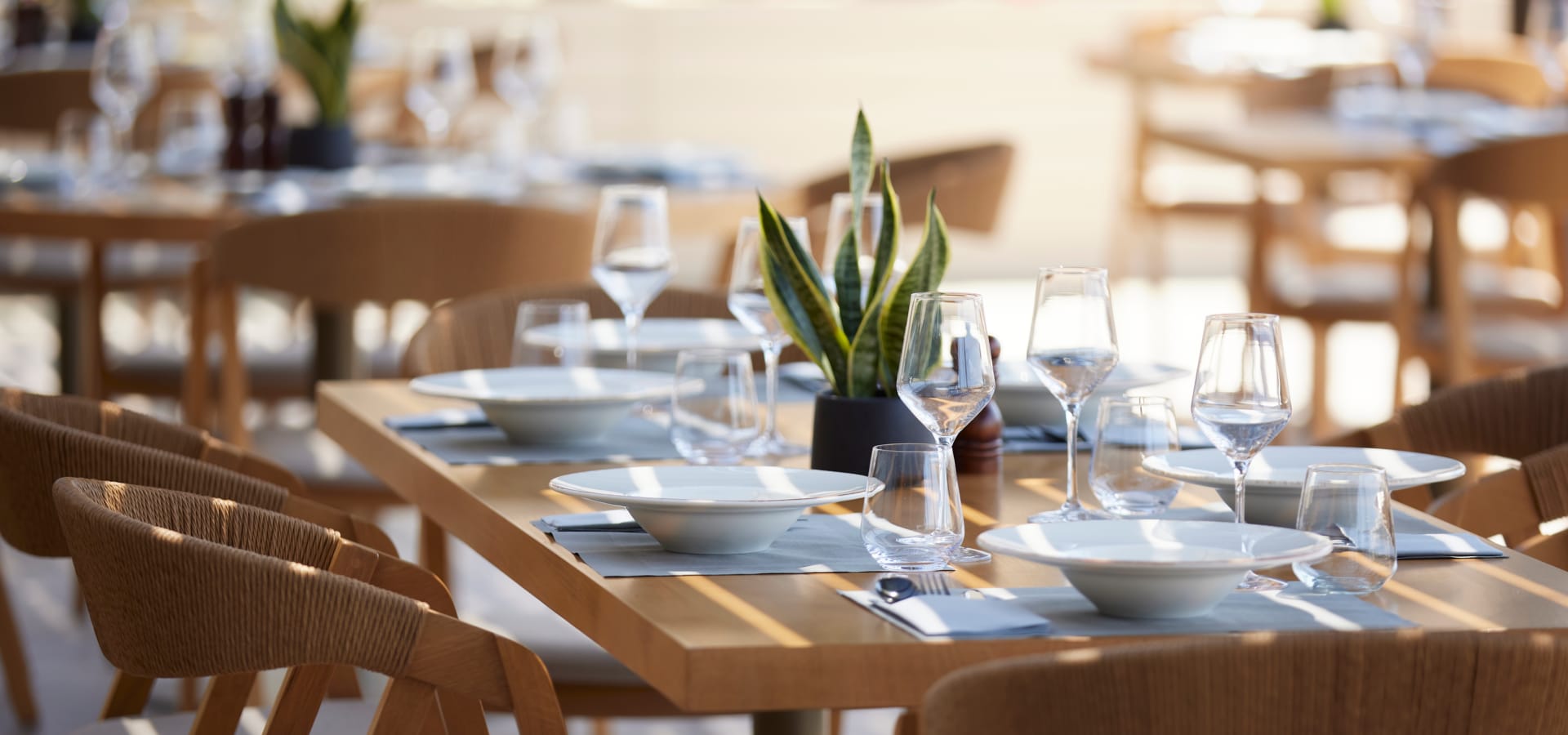 a set of tables with plates and glasses on them