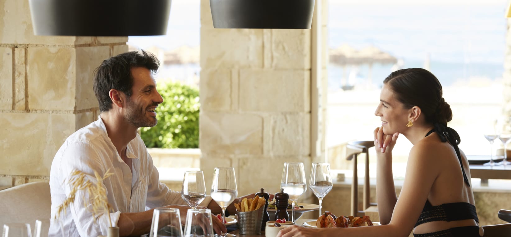 a man and a woman sitting at a table with wine glasses