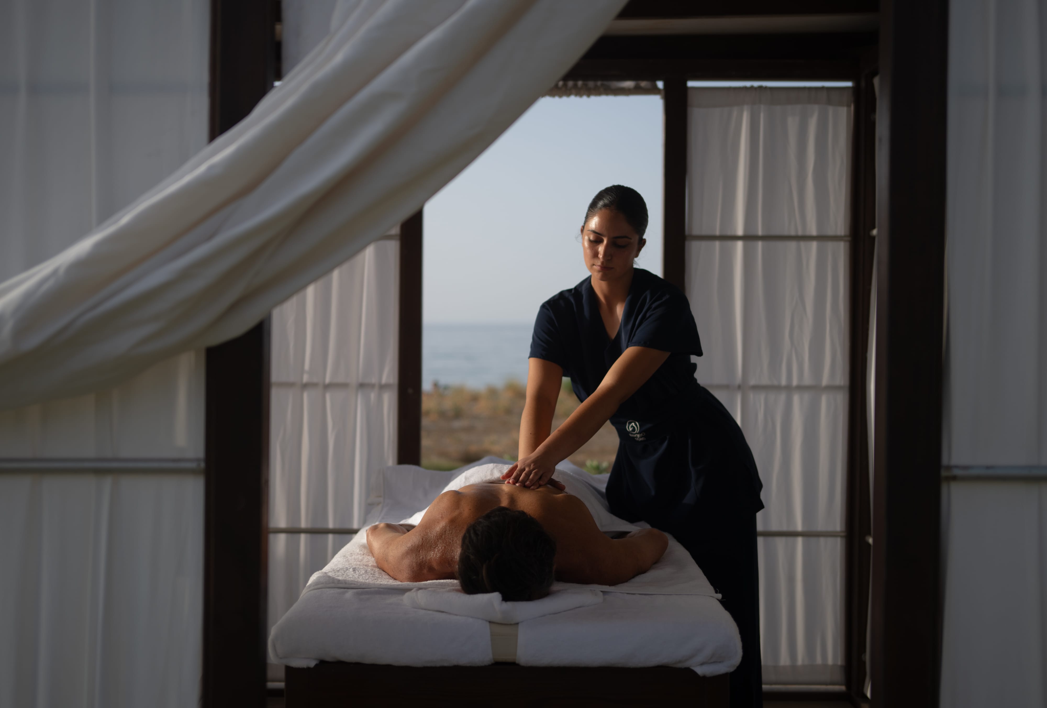 a woman standing over a man lying on a bed