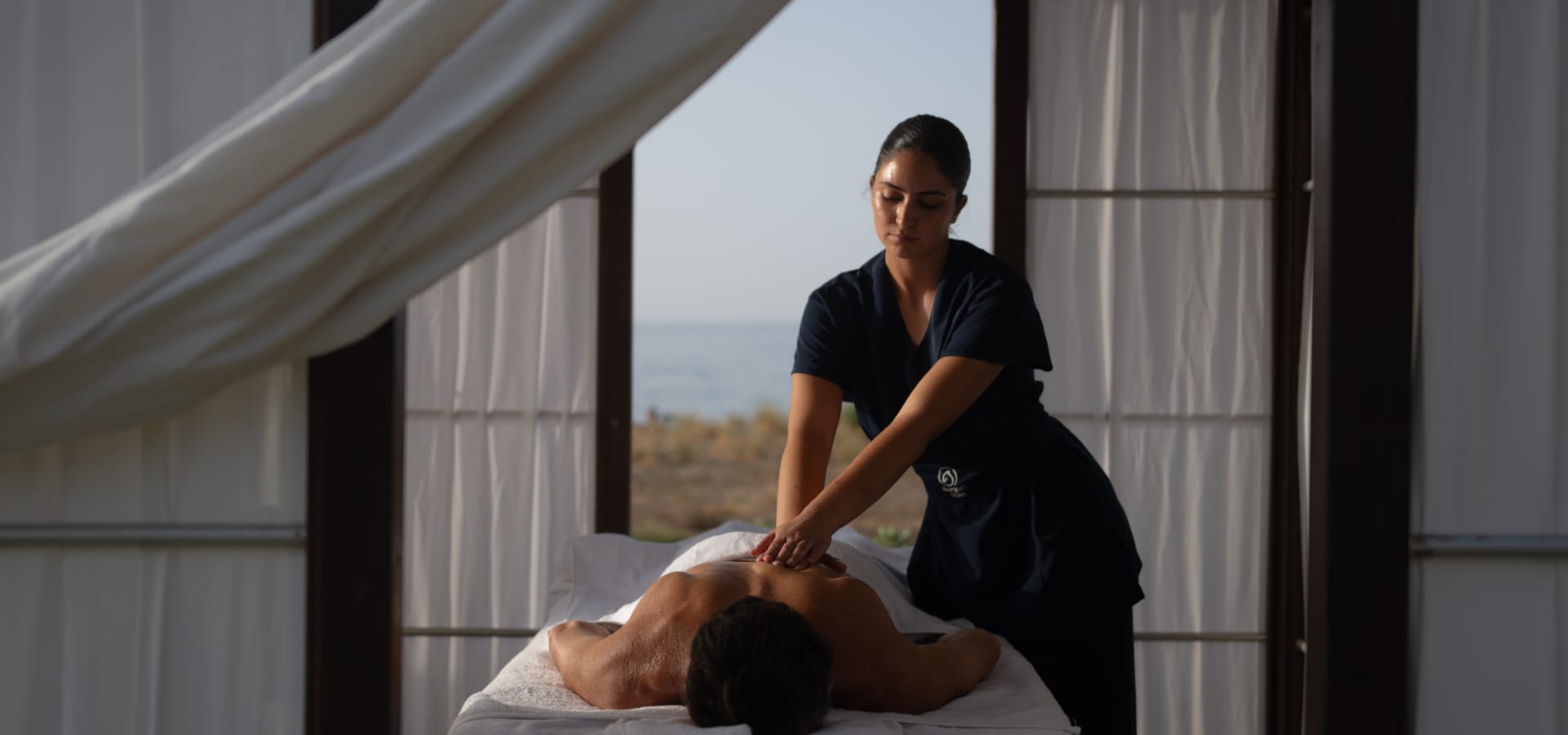 a woman standing over a man lying on a bed