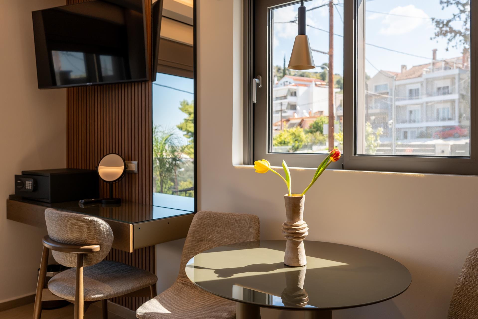 a vase with yellow flowers on a table in a room with a window