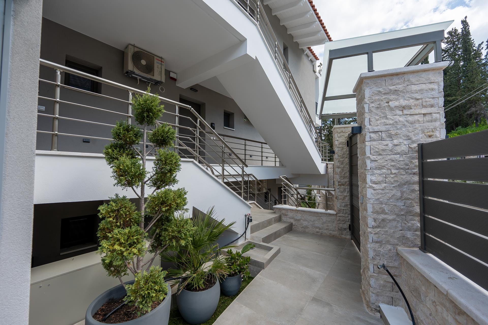 a building with a staircase and potted plants