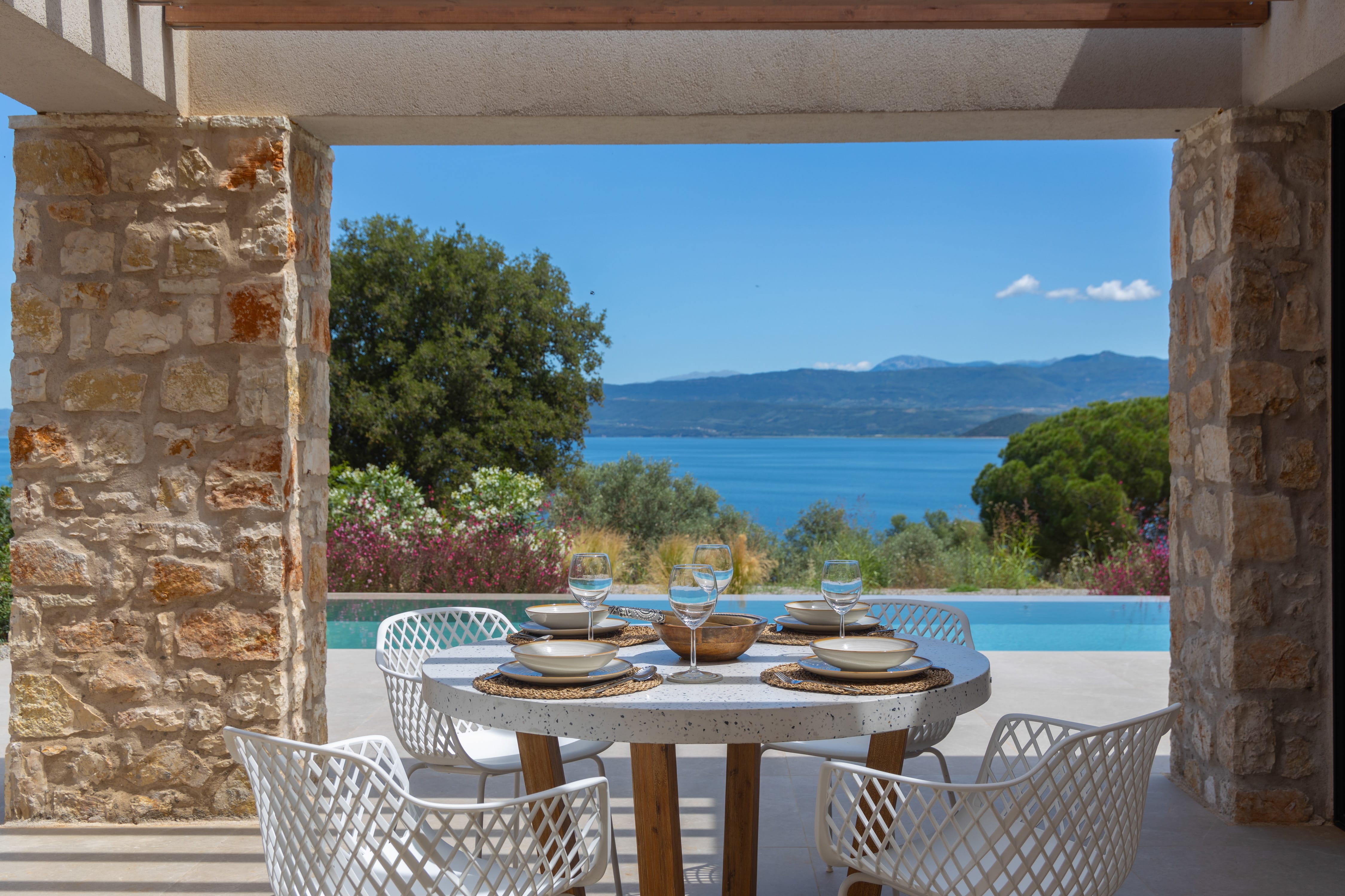 a table with plates and glasses on it by a pool