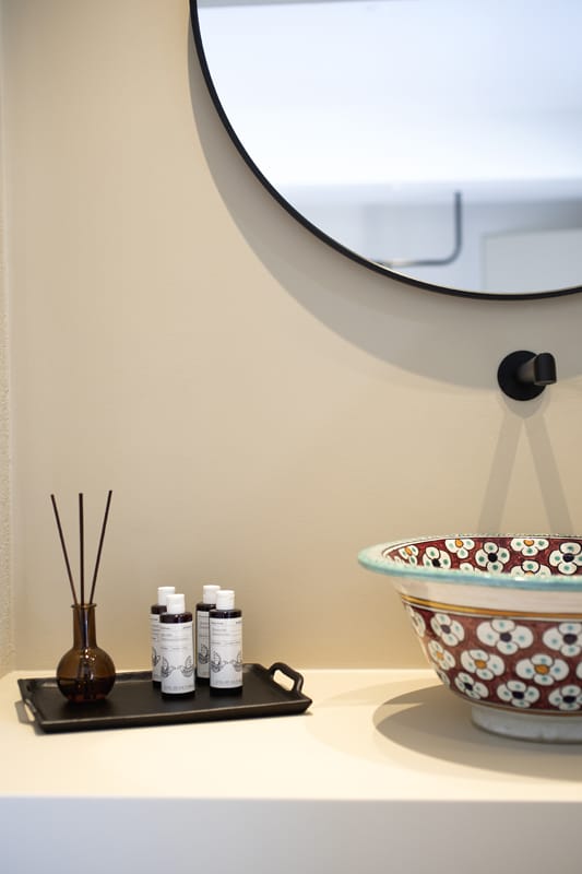 a table with a bowl and a vase with flowers on it