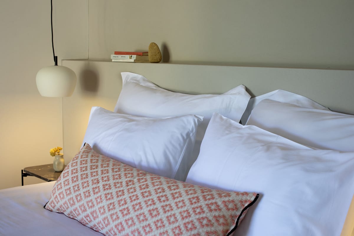 a couple of beds with white sheets