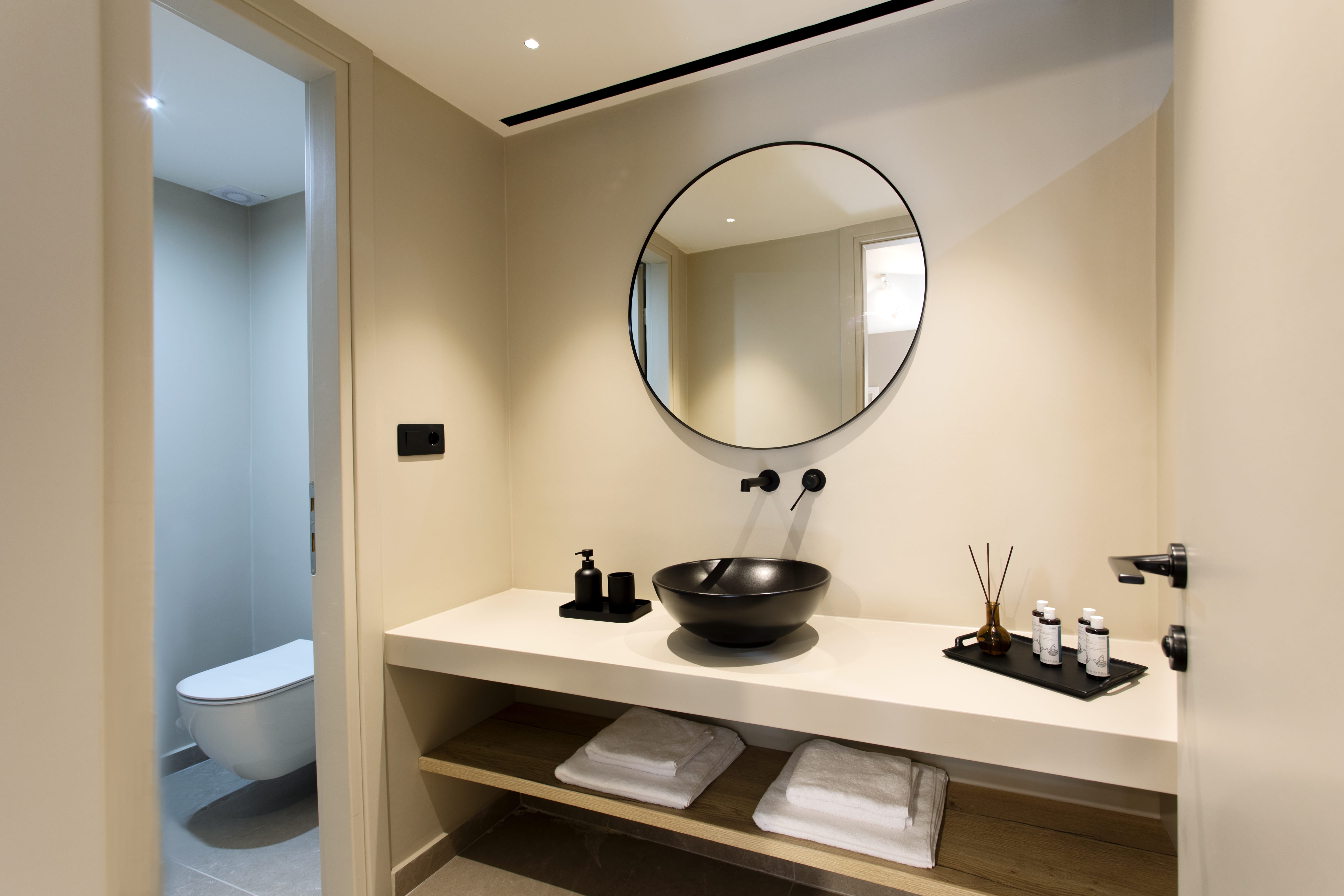 a bathroom with a round mirror
