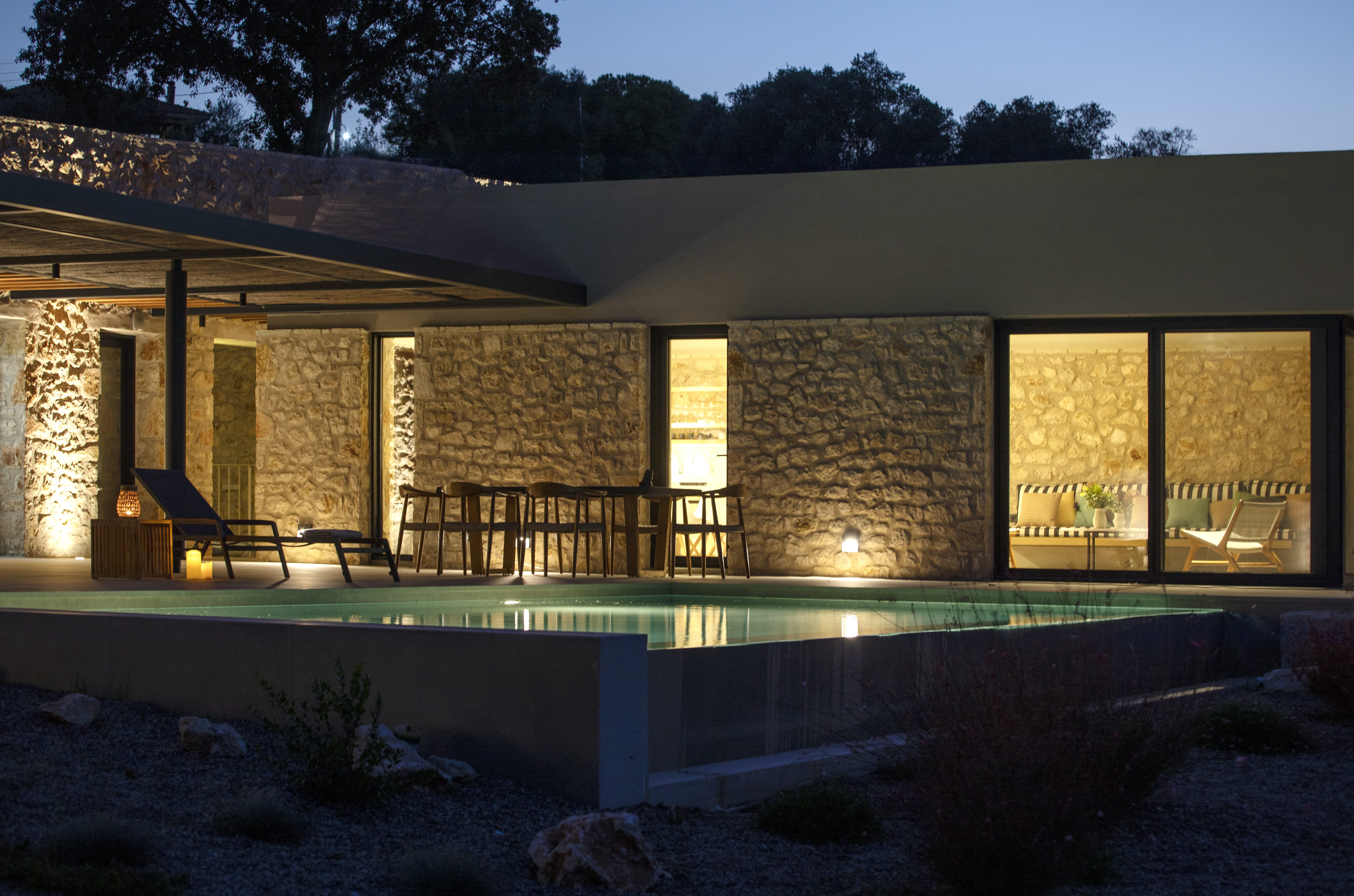 a house with a pool and a deck with lights on