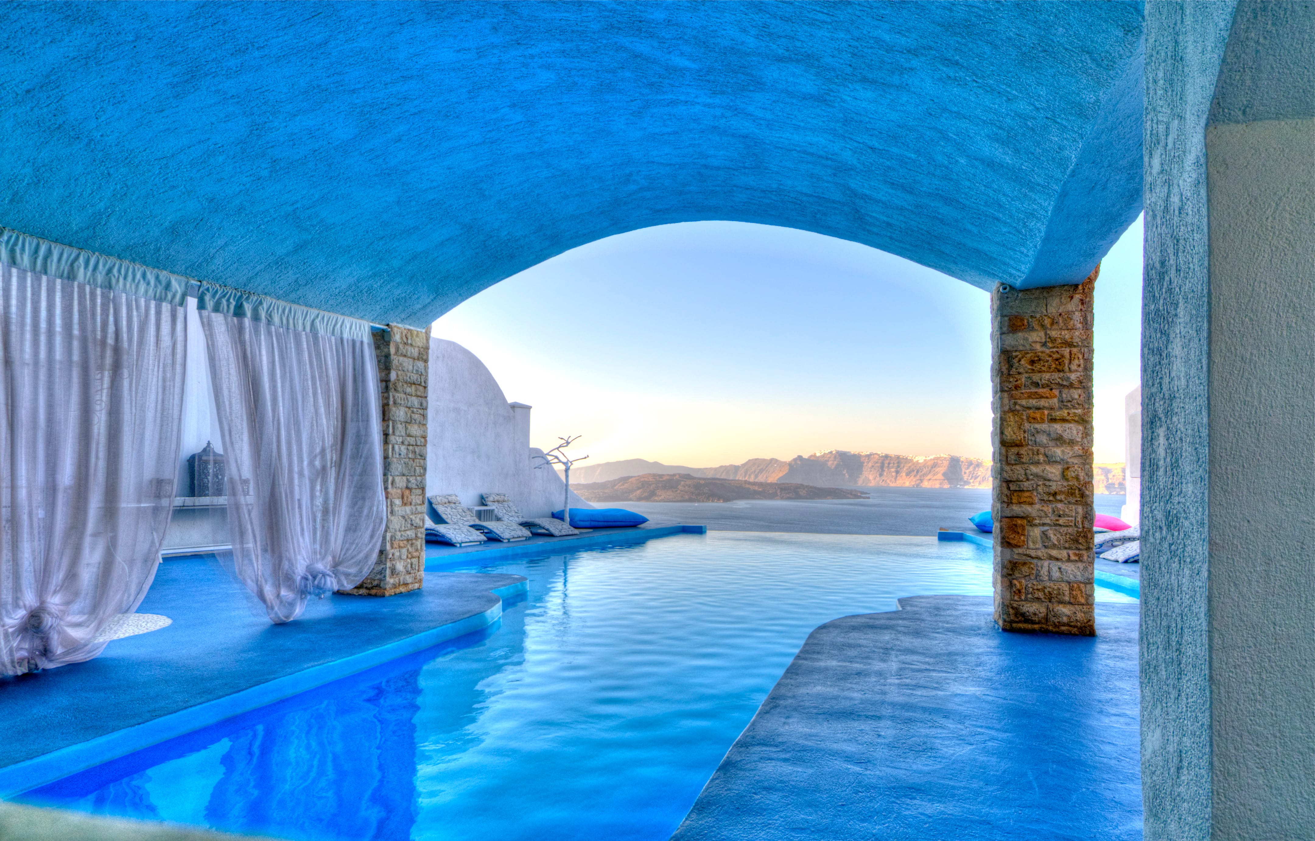 a pool with a view of the ocean and a sunset