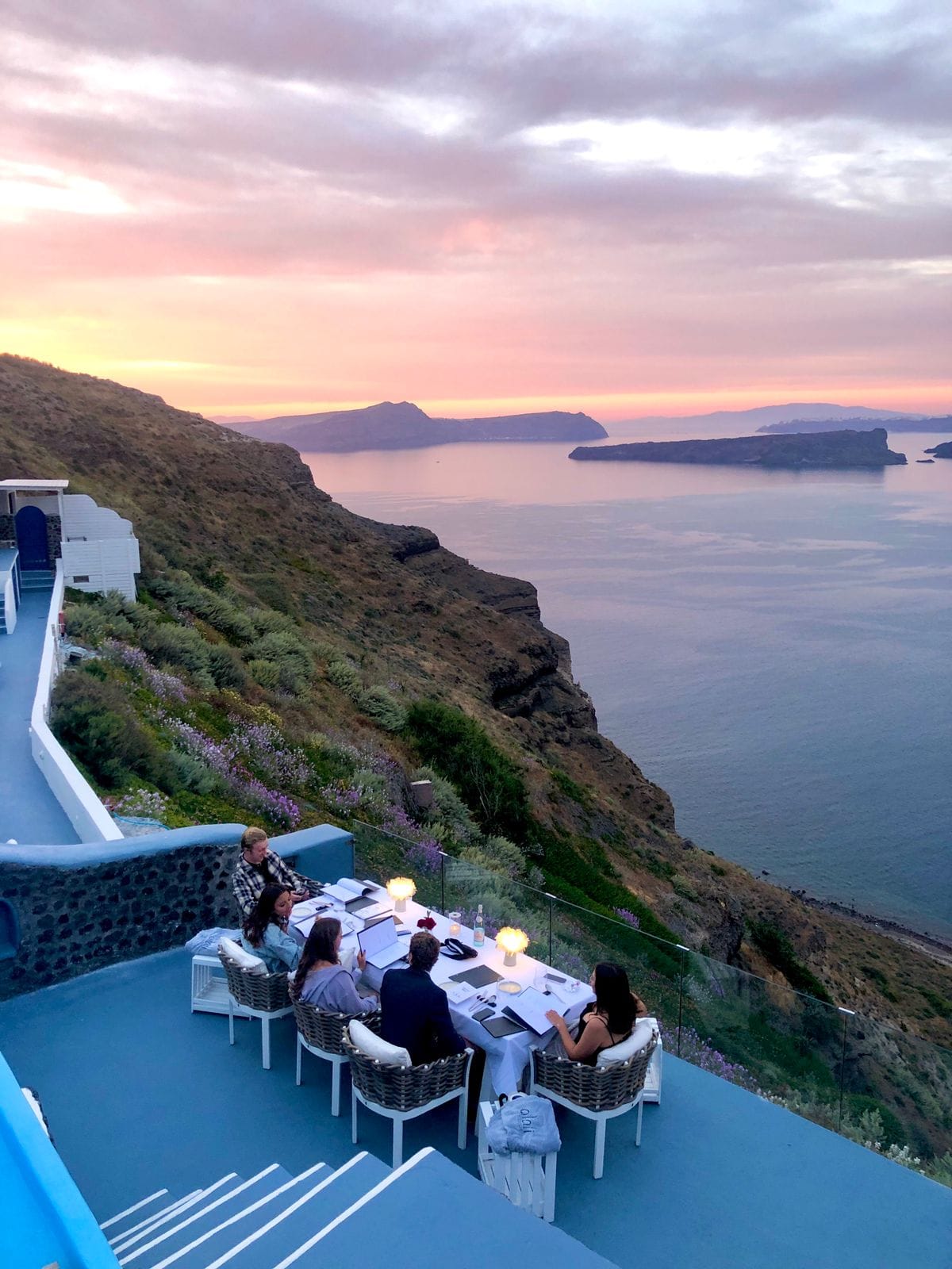 a group of people sitting on a deck overlooking a body of water