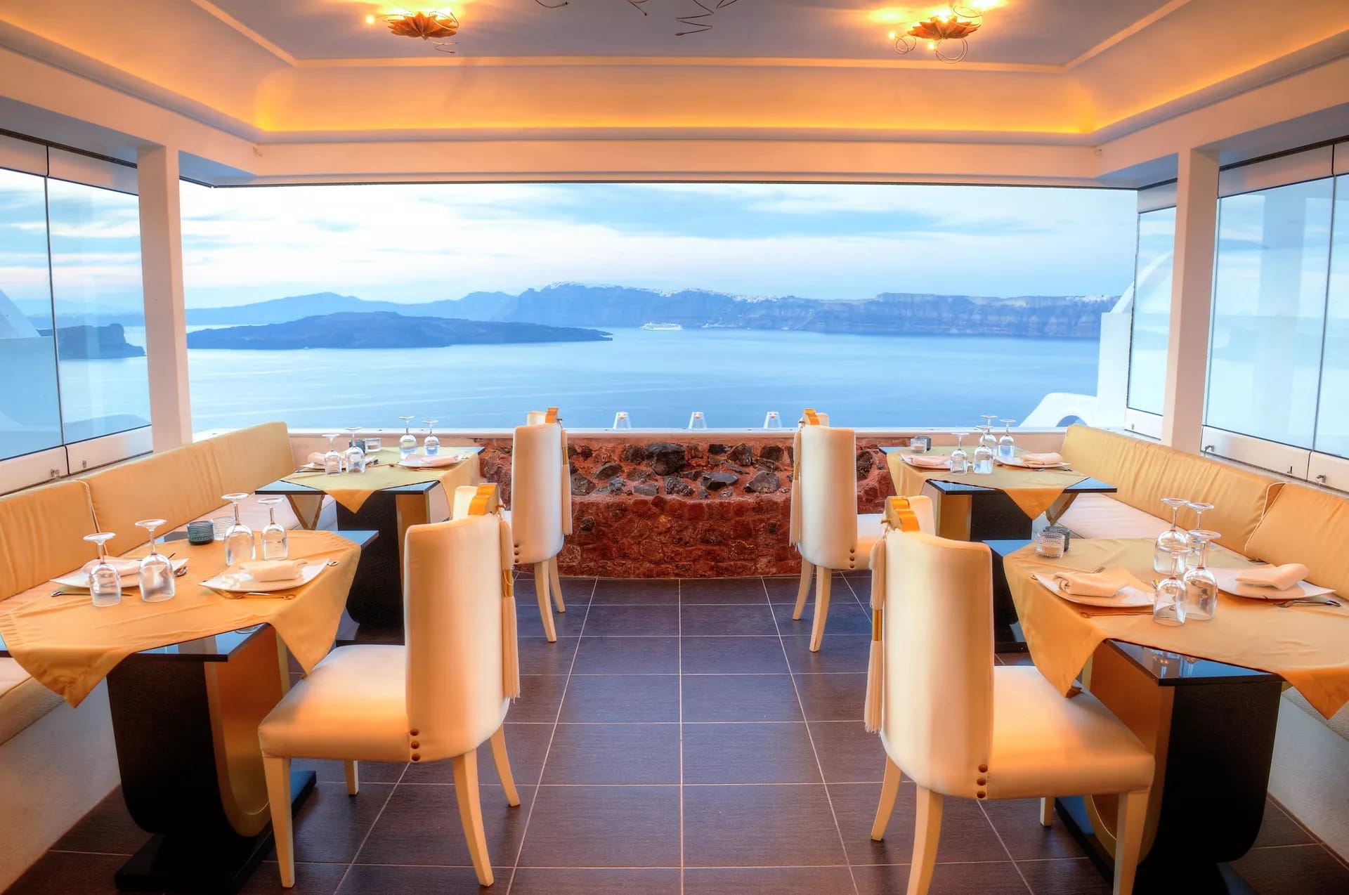 a room with tables and chairs and a large body of water