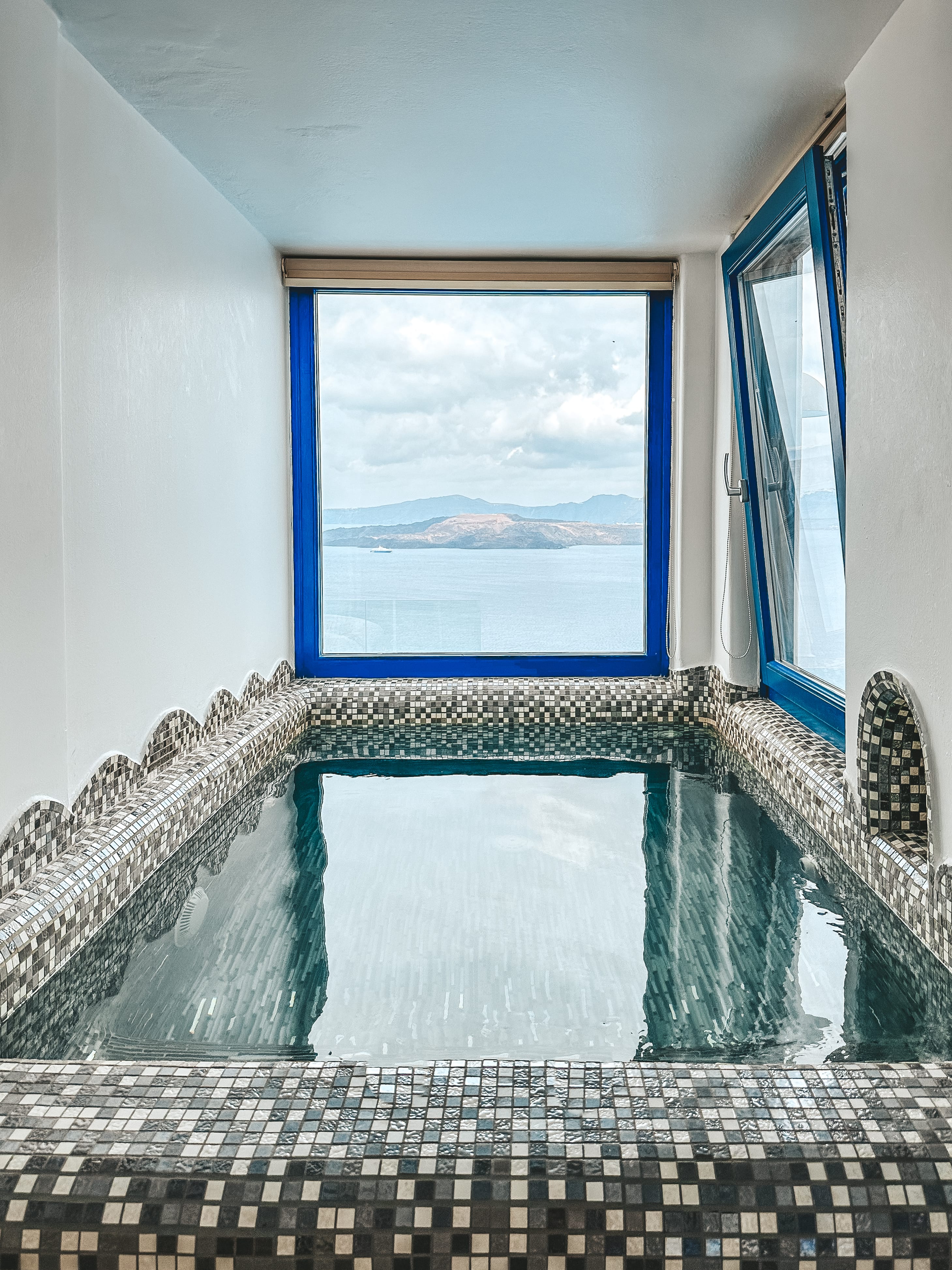 a window with a view of the ocean and a stairway