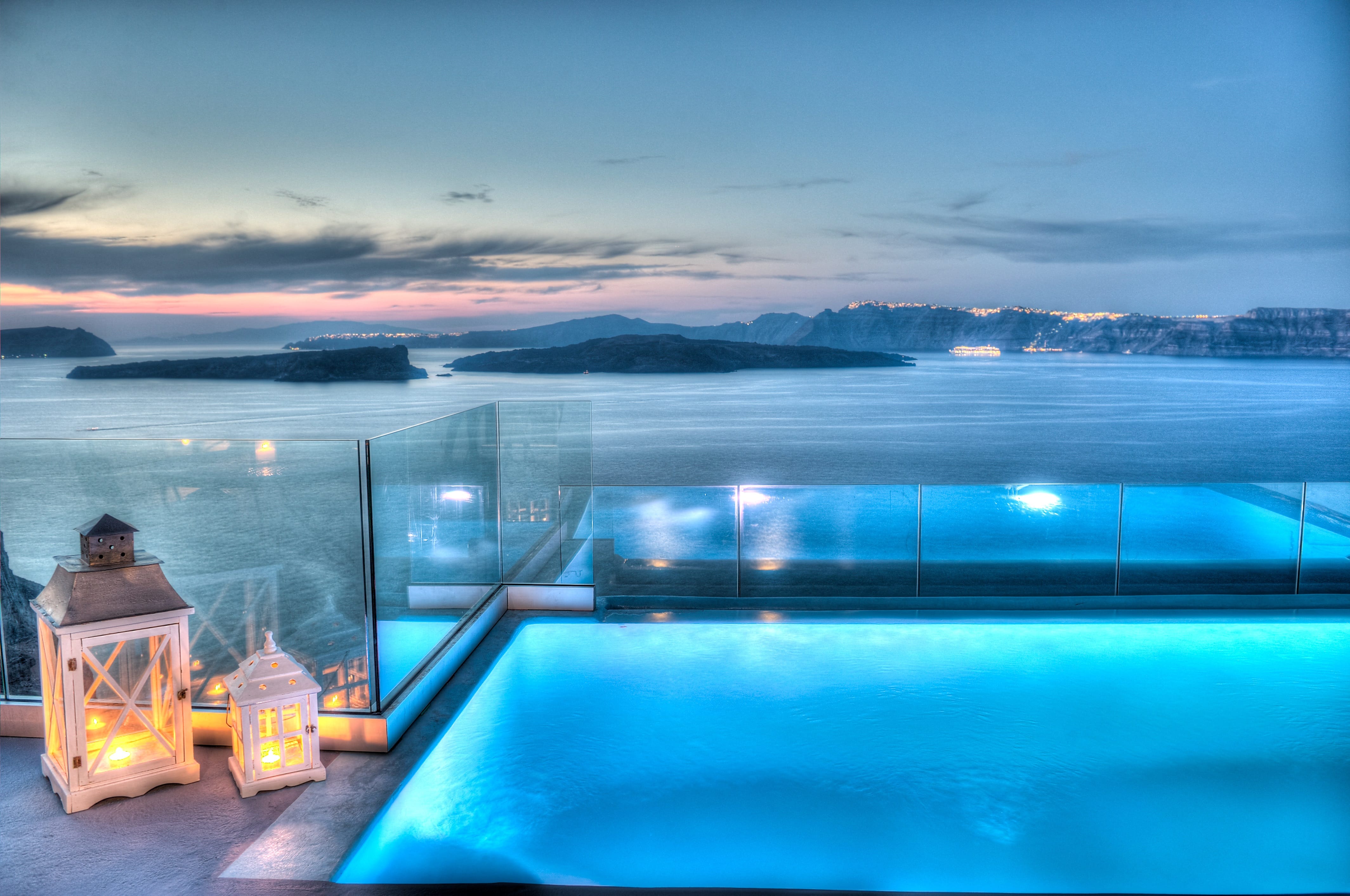 a pool with a view of the ocean and a city at night