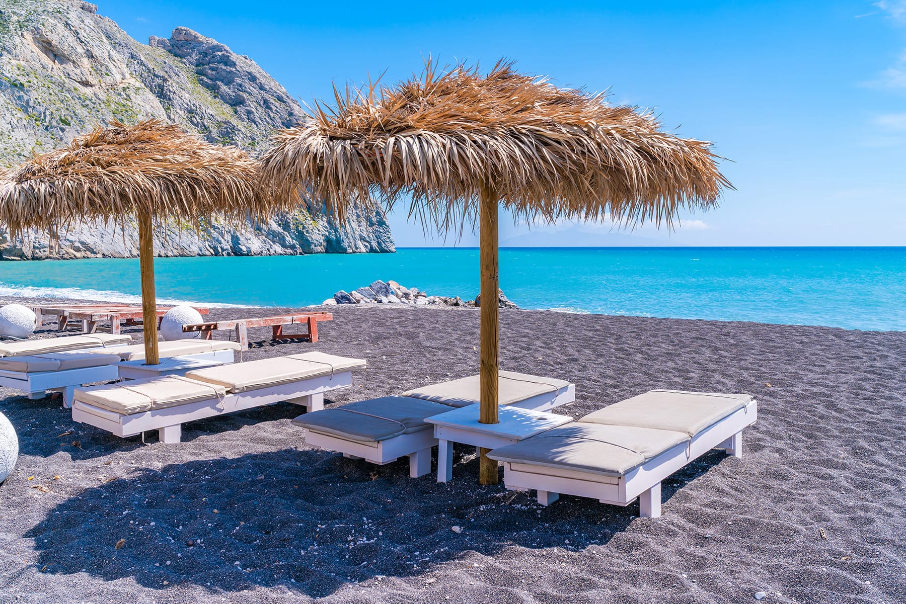 a beach with lounge chairs and umbrellas