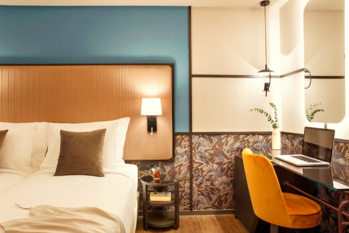 a bedroom with a bed desk and lamp