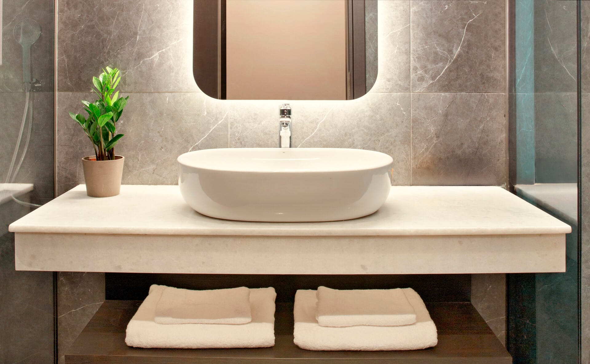 a white sink with a plant on the side