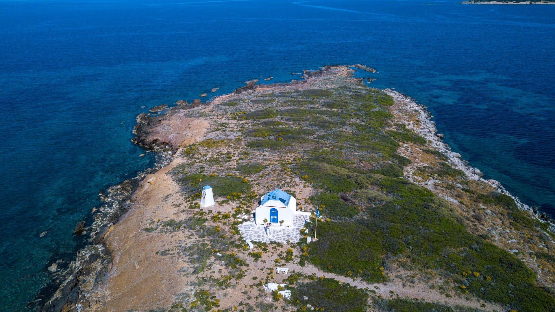 a small white house on a hill by the ocean