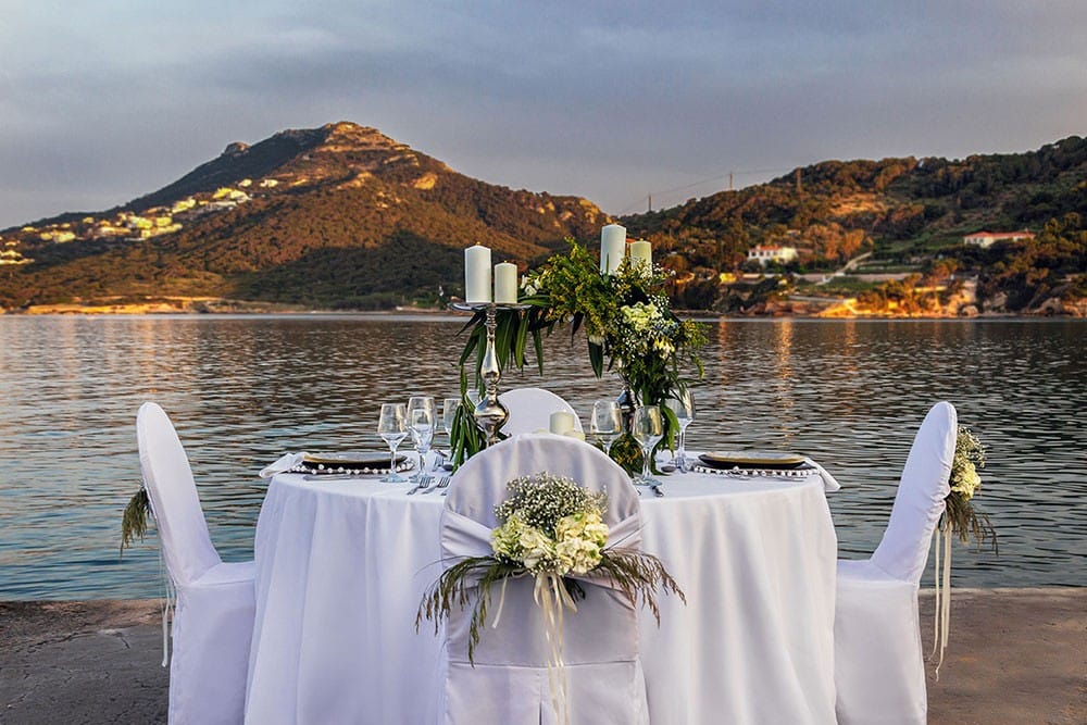 a table with white chairs and flowers