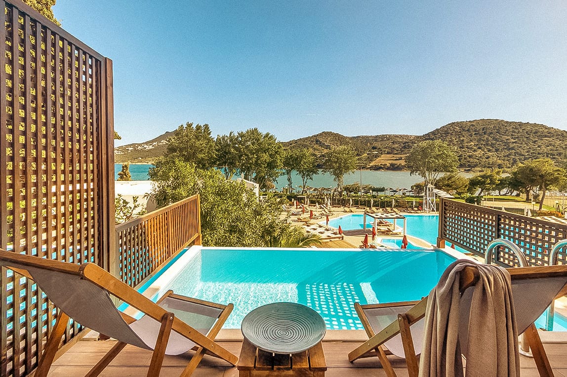 a pool with chairs and a table on a balcony