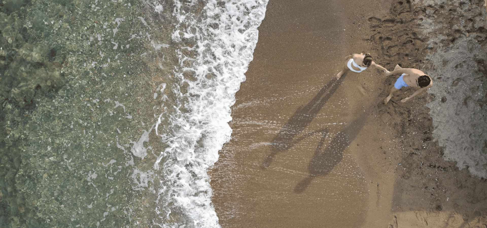 a man and woman standing on a beach