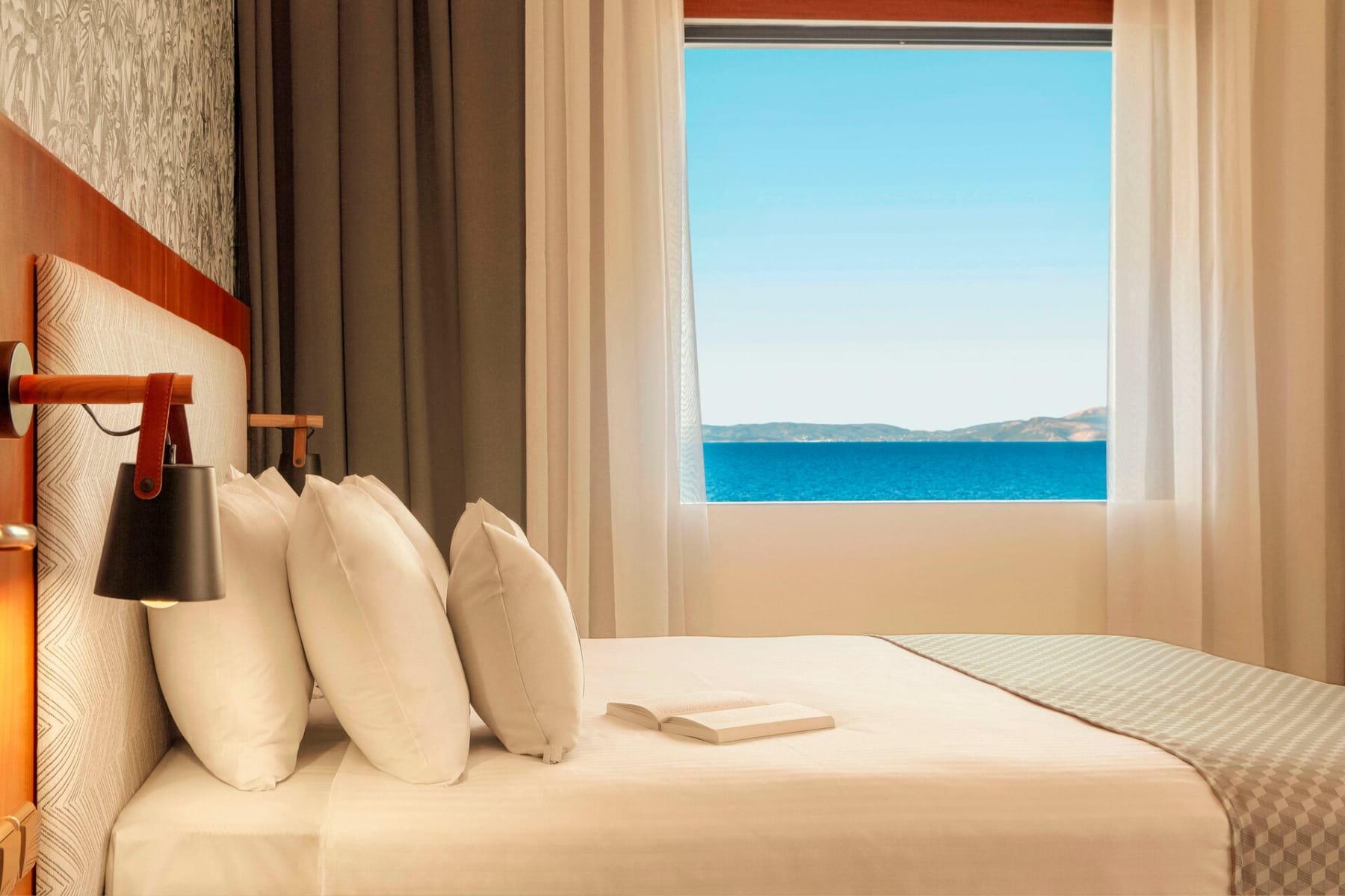 a bed with pillows and a lamp