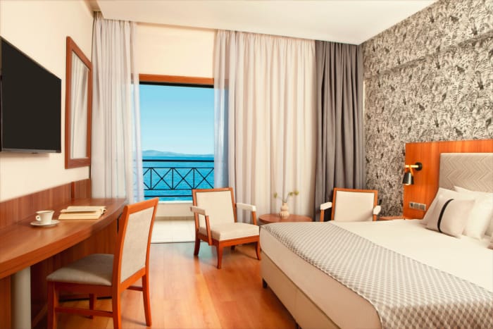 a bedroom with a bed desk and chairs