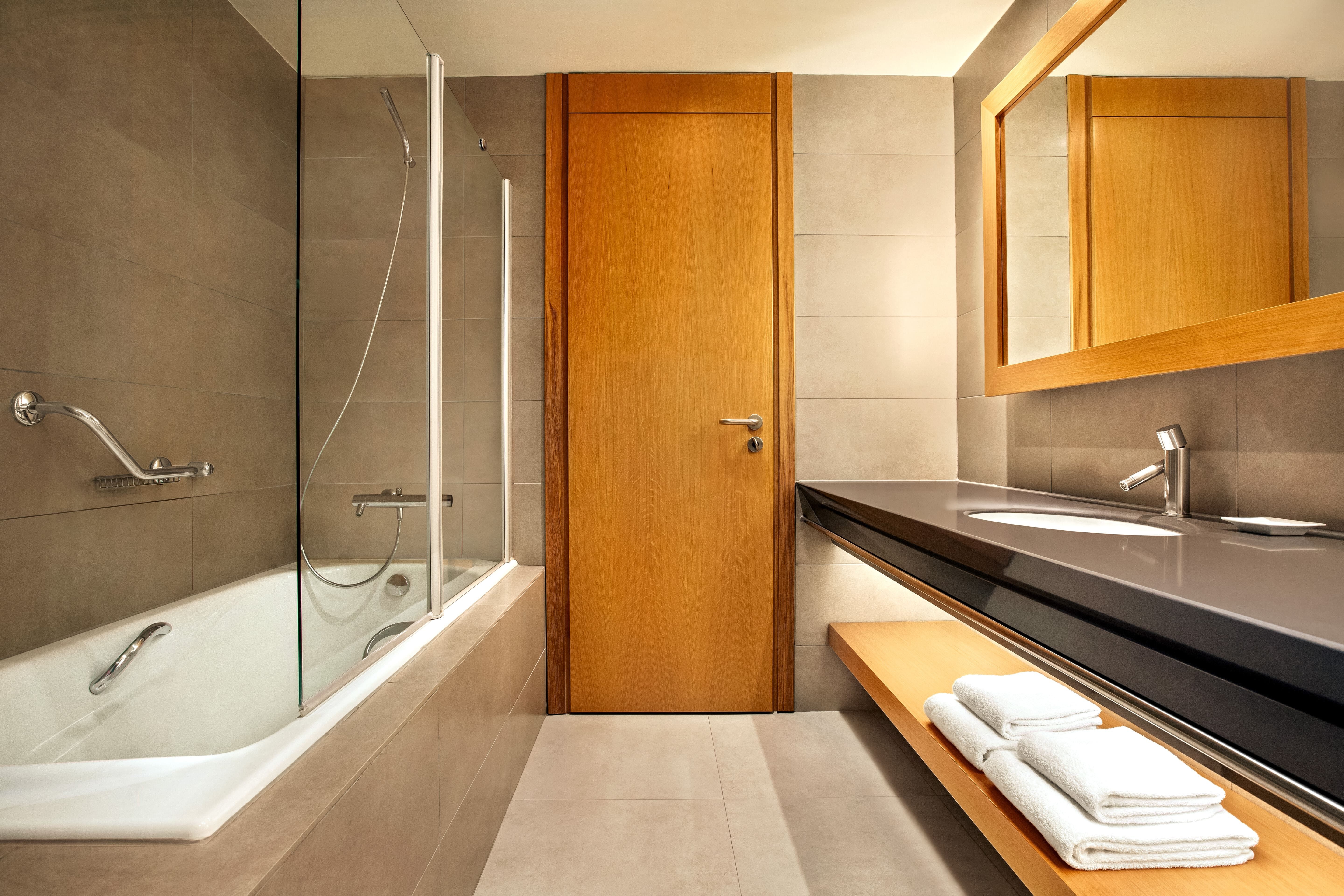 a bathroom with a wooden door and a bathtub