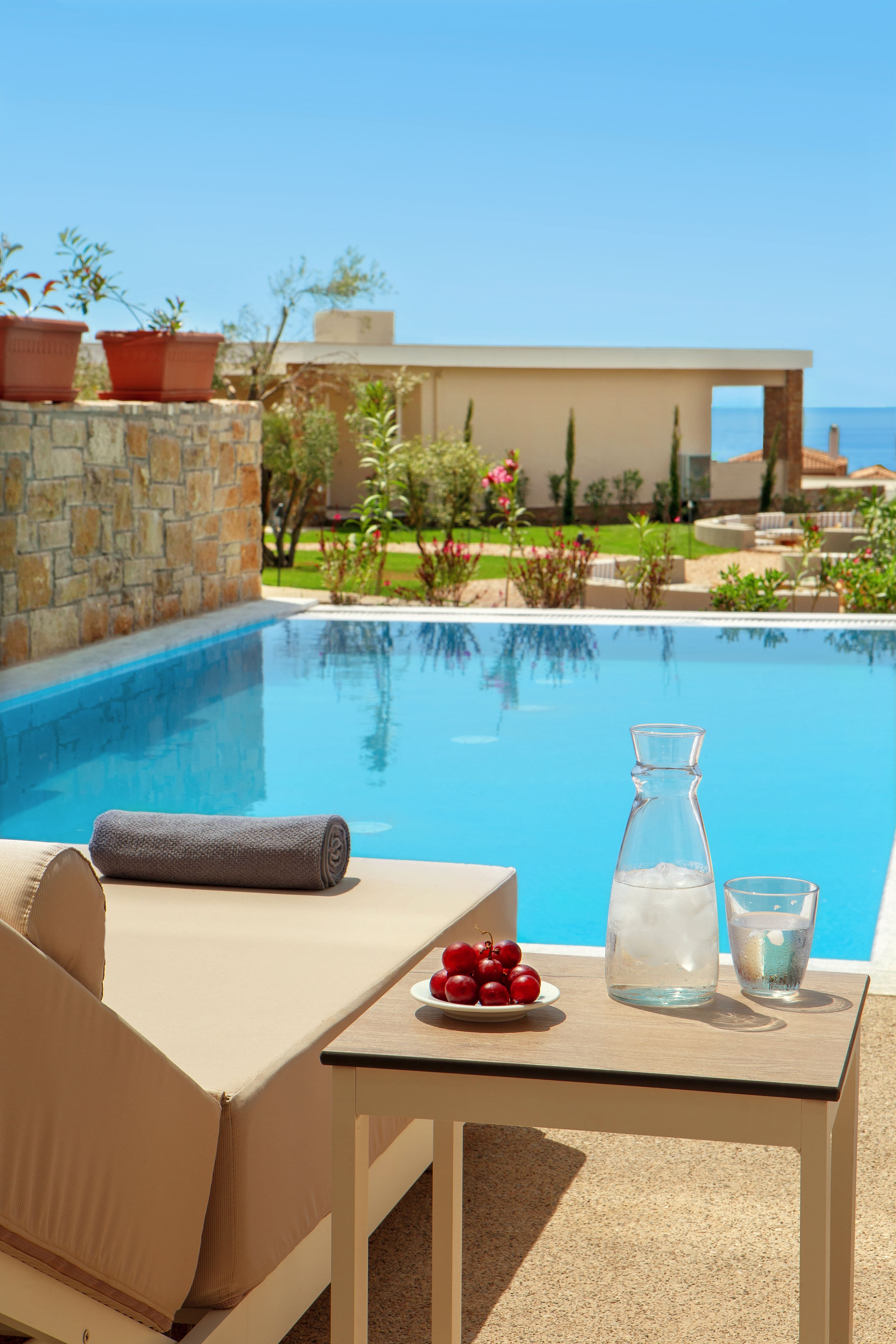 a pool with a table and a plate of fruit