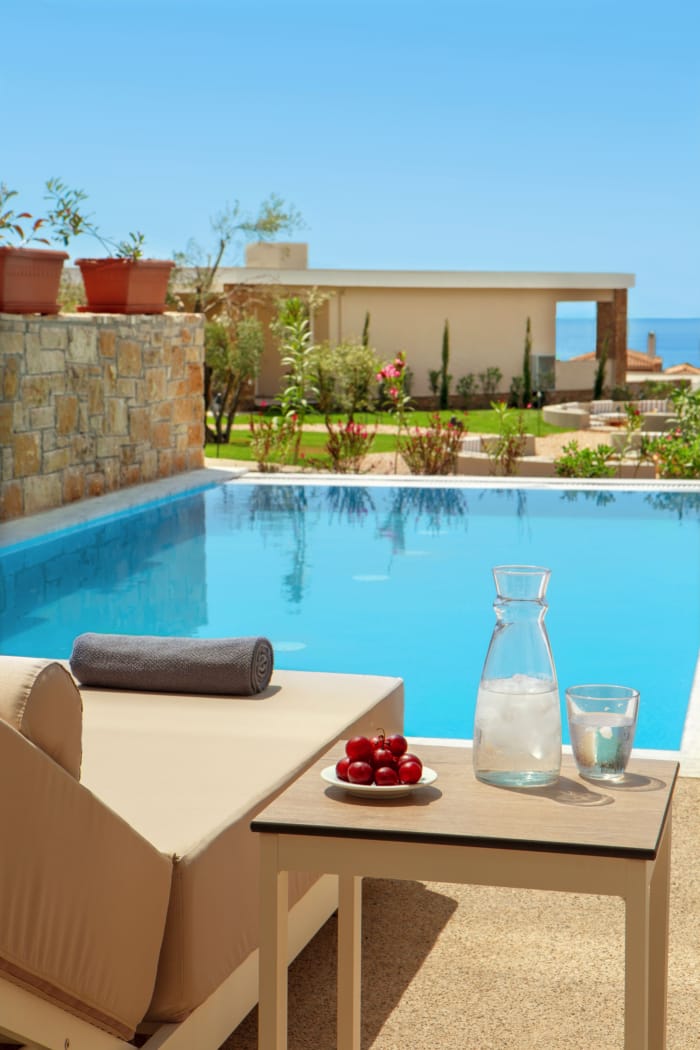 a pool with a table and a plate of fruit