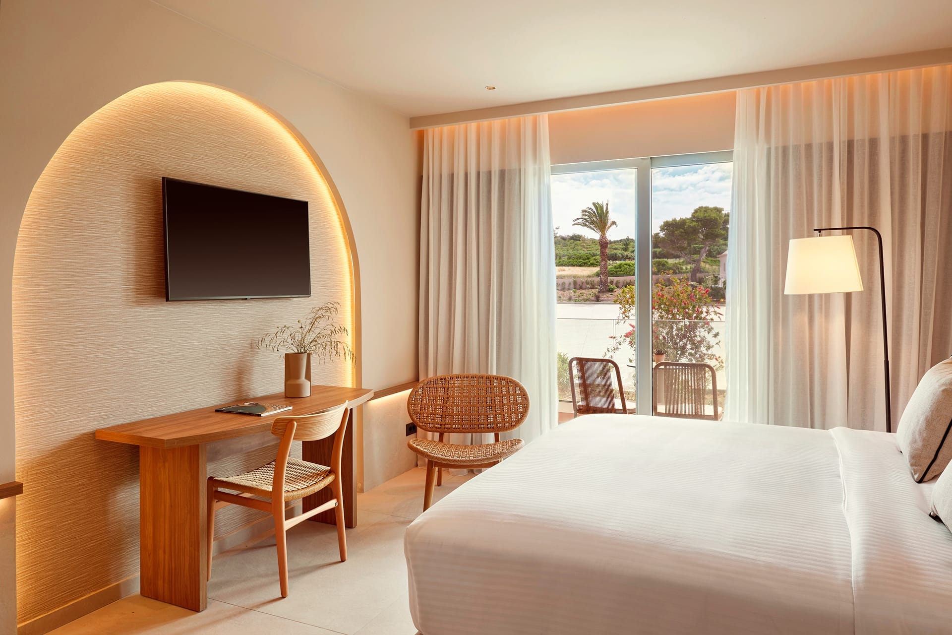 a bedroom with a bed desk and a large window