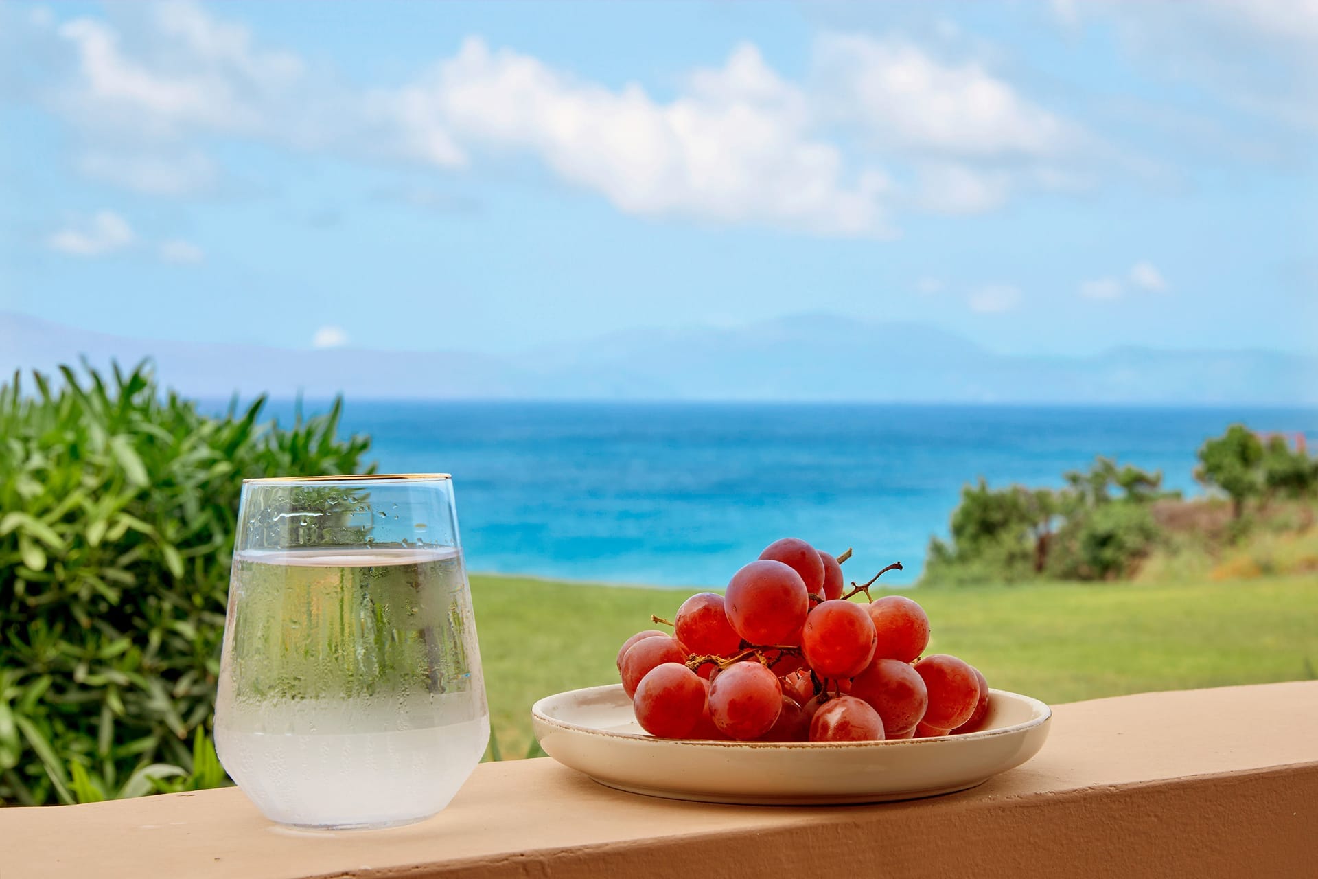 a glass of milk next to a bowl of cherries and a glass of milk on a table