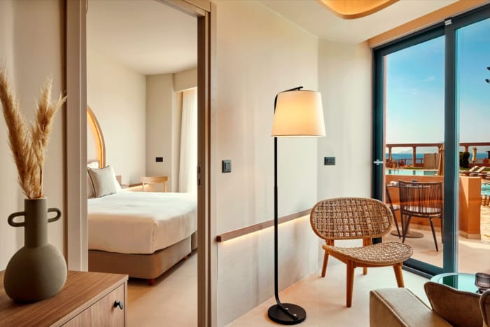 a bedroom with a bed and chairs