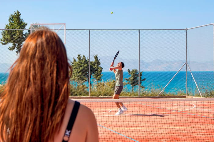 a woman watching a man play tennis
