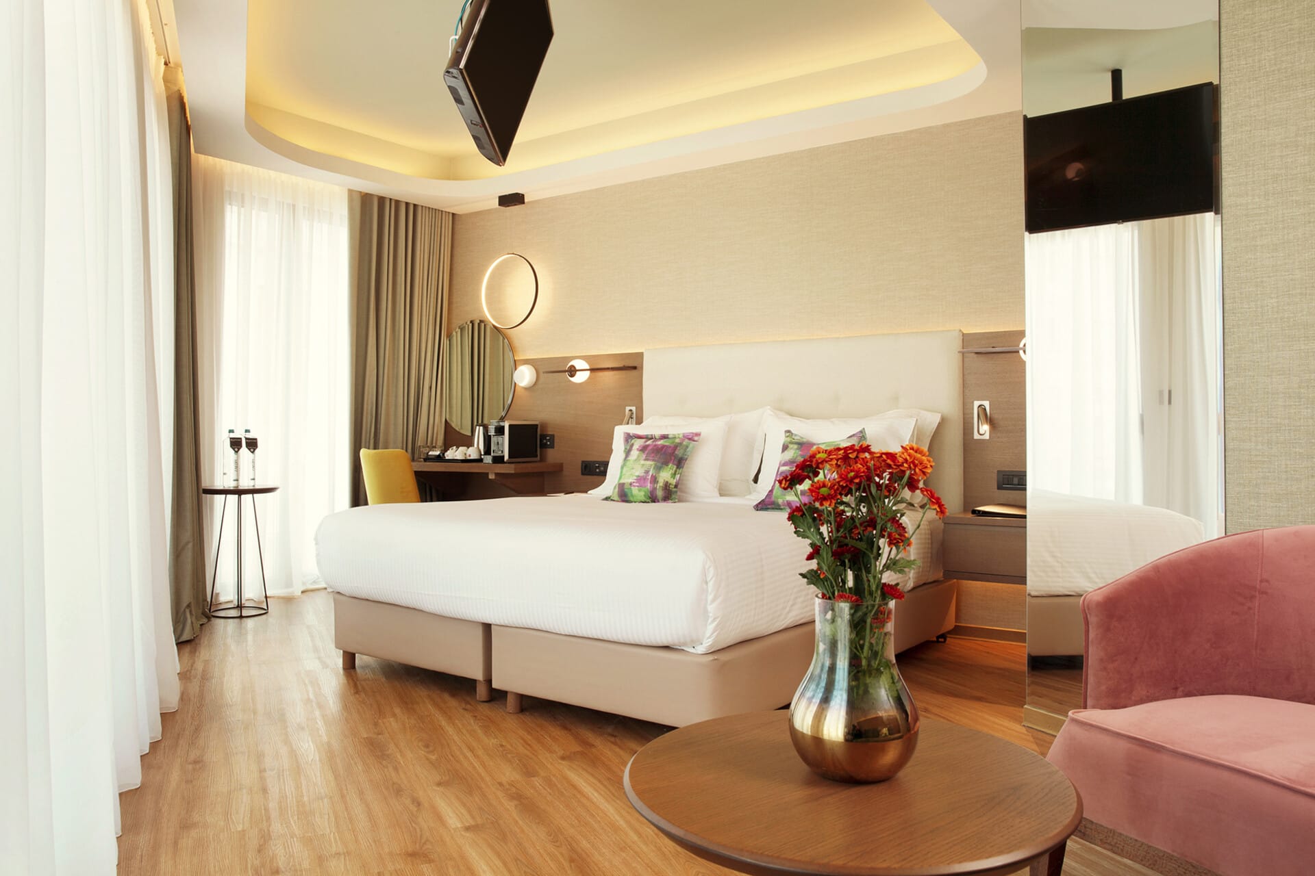 a living room with a white couch and a table with a vase of flowers