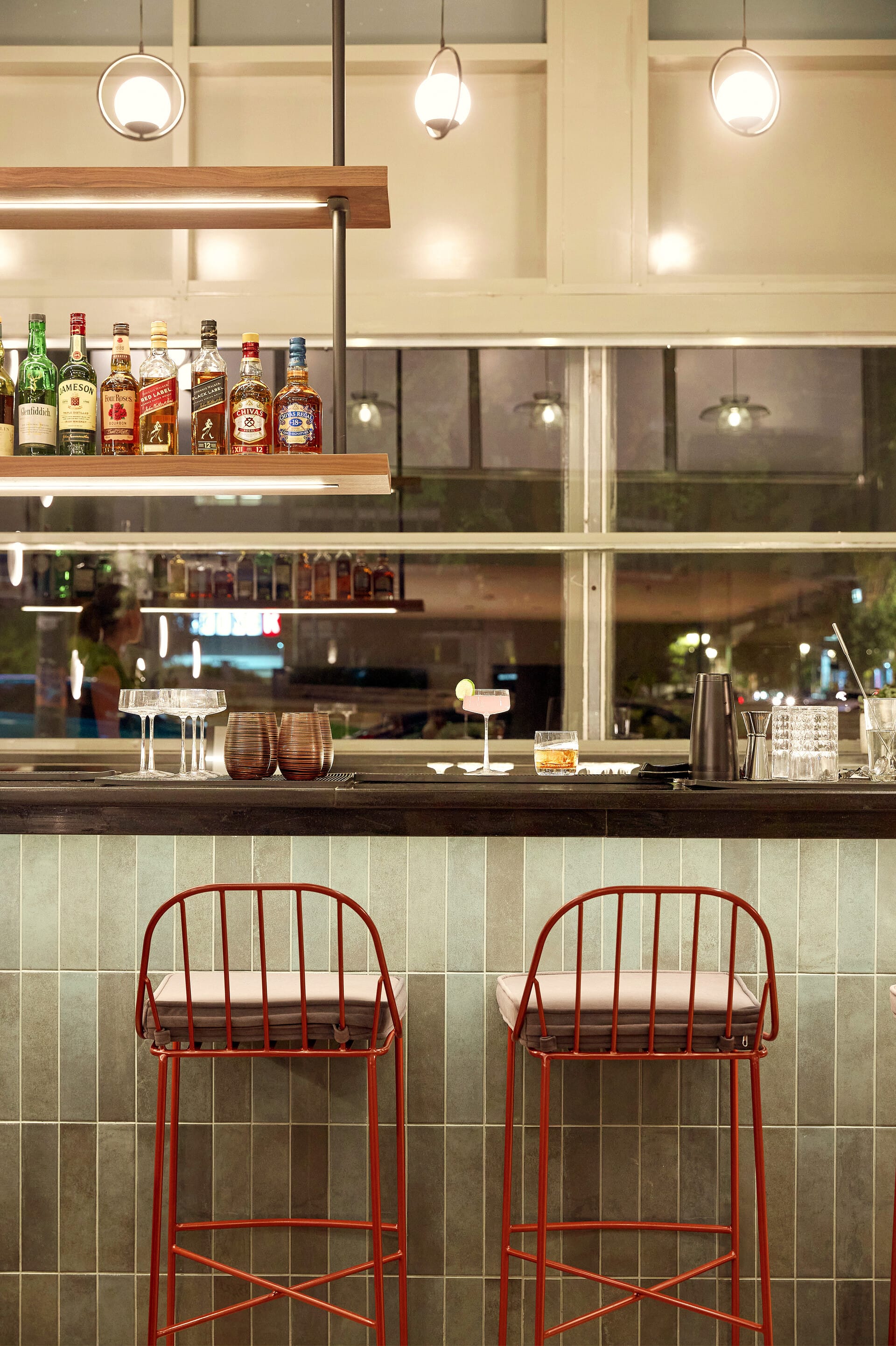 a bar with stools and bottles
