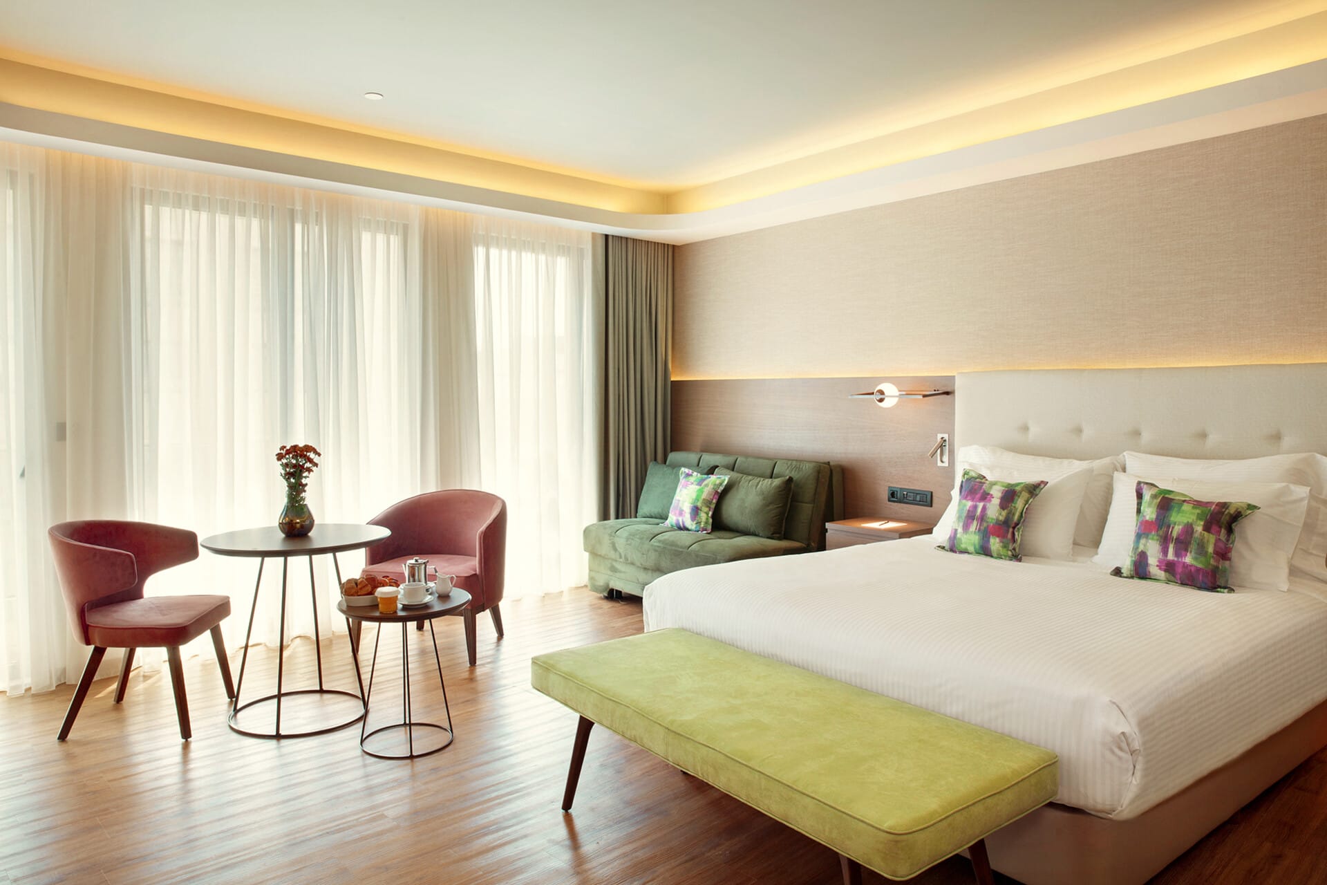 a room with a bed and chairs