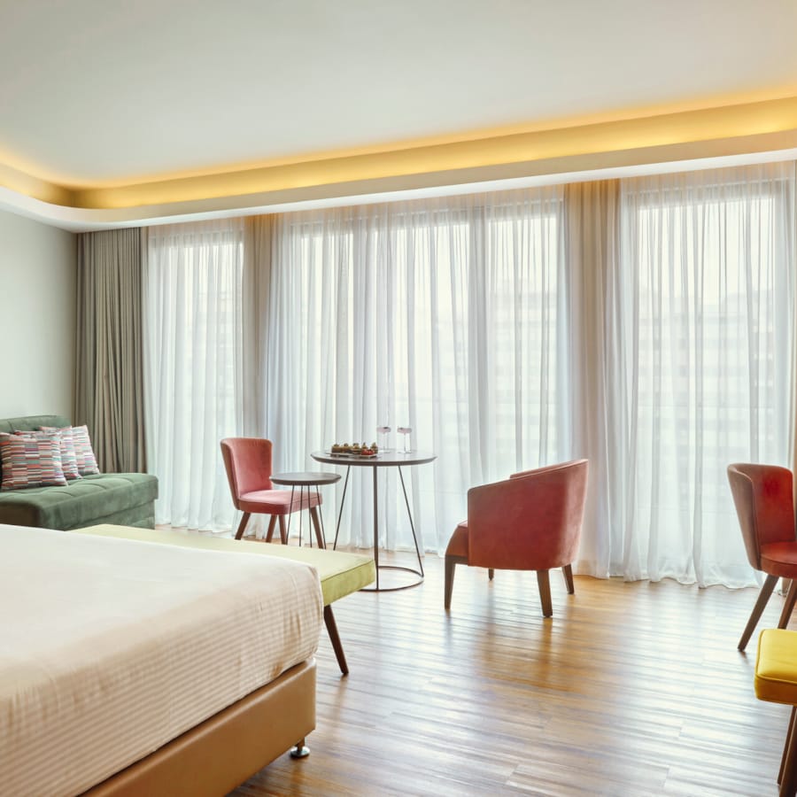 a room with a bed and chairs