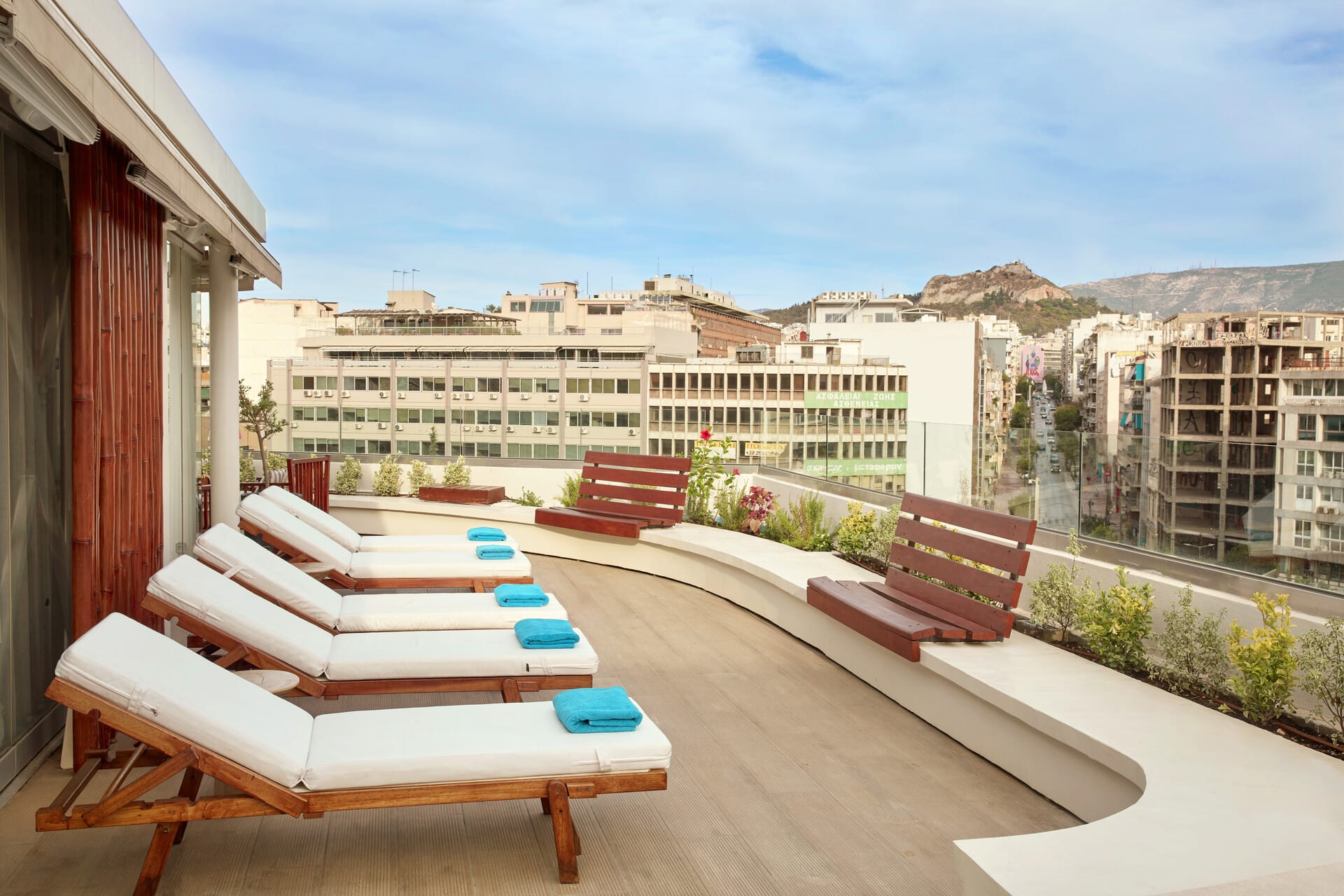 a deck with chairs and tables on it next to a building