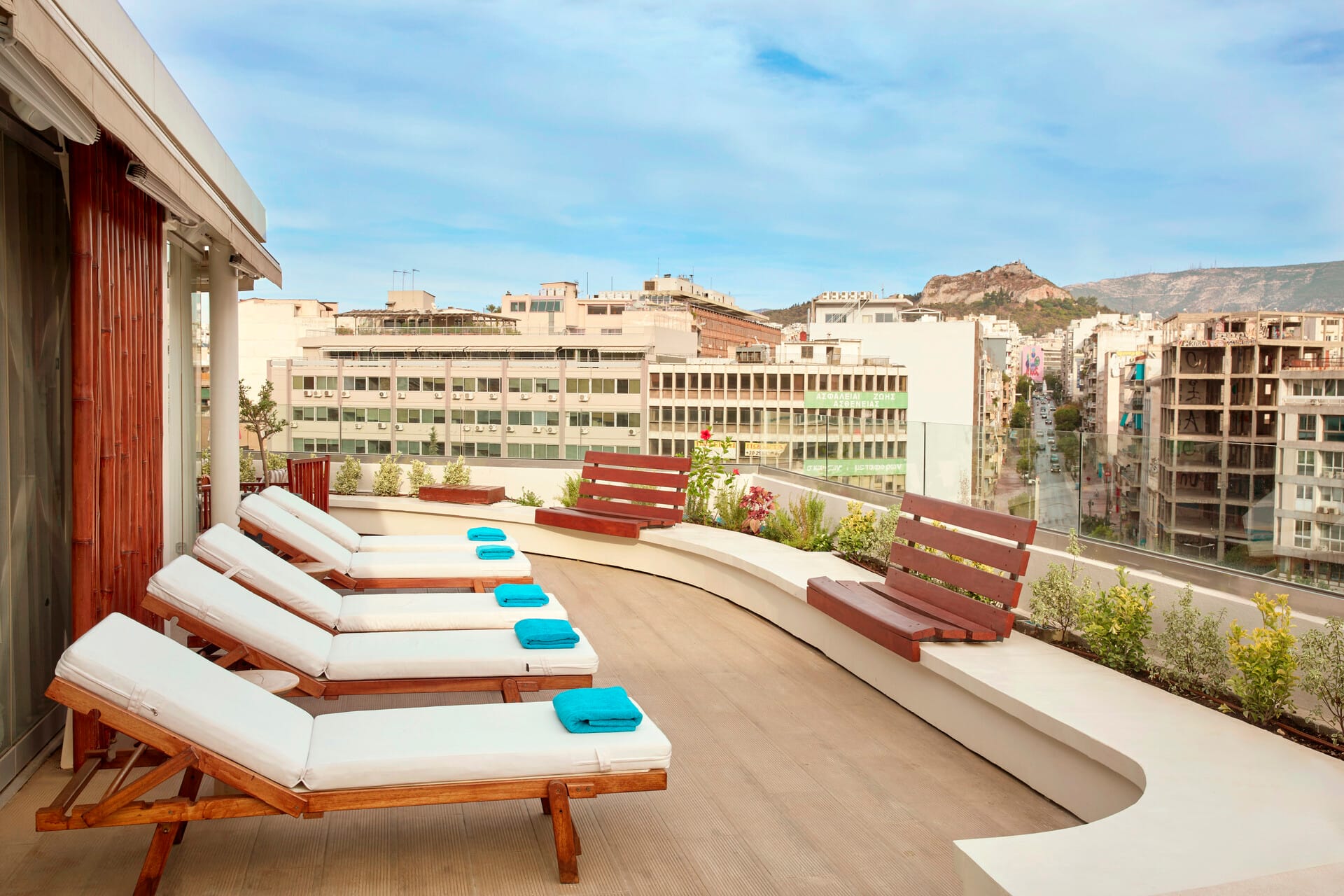 a deck with chairs and tables on it next to a building