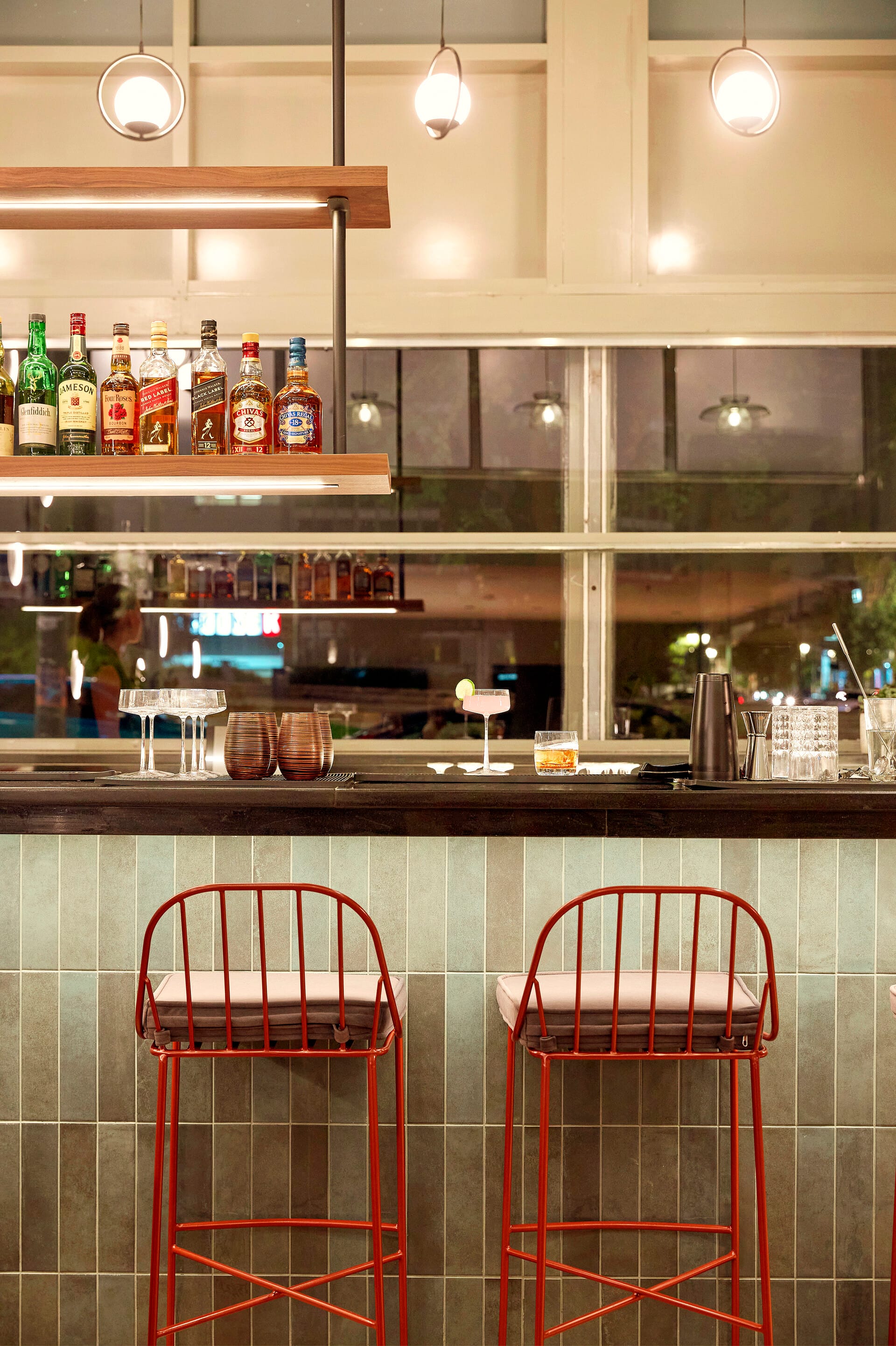 a bar with stools and bottles