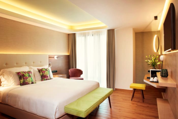 a hotel room with a bed and a bench