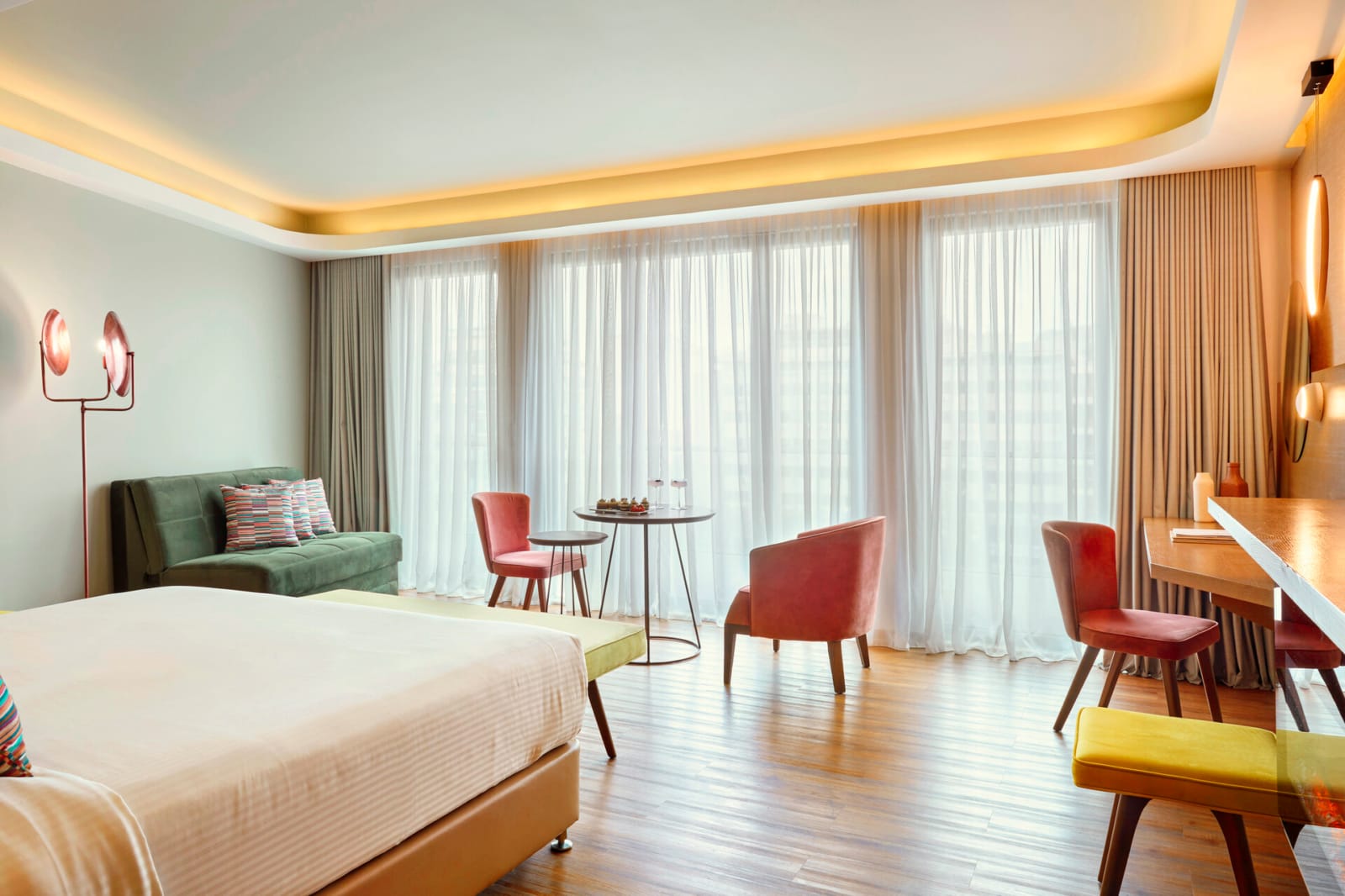 a room with a bed and chairs