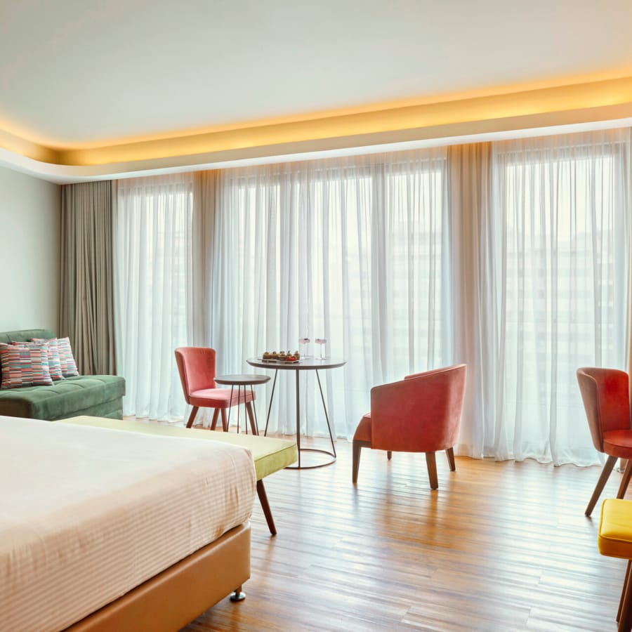 a room with a bed and chairs