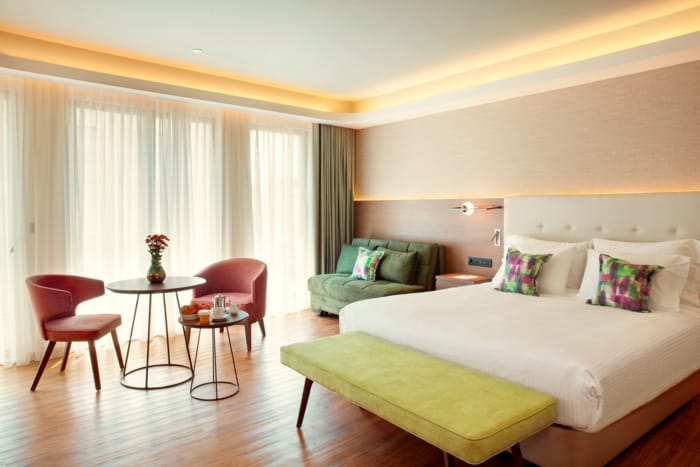 a room with a bed and chairs