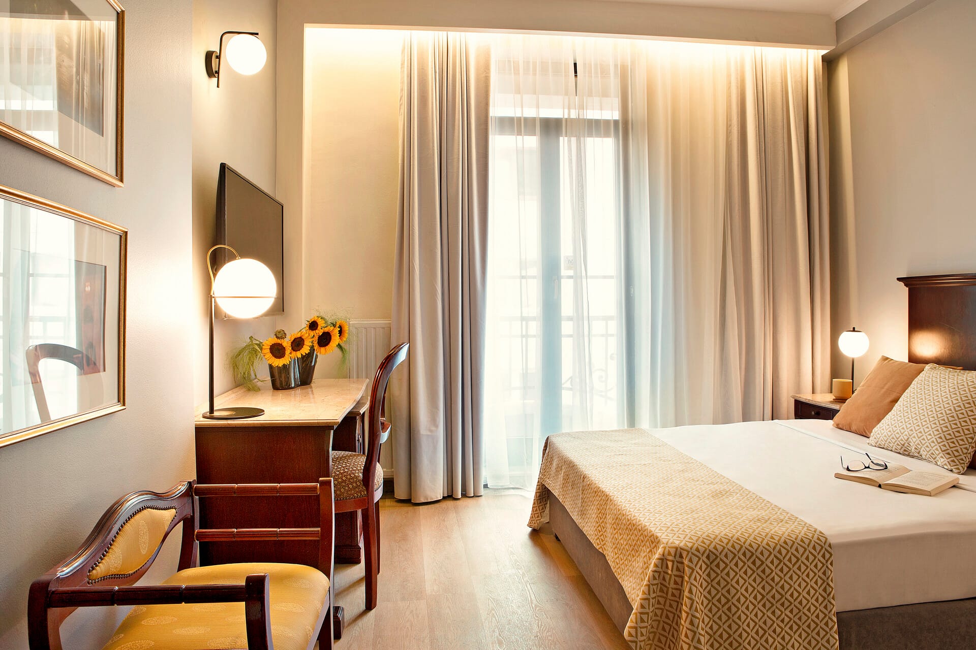 a hotel room with a bed desk and a mirror