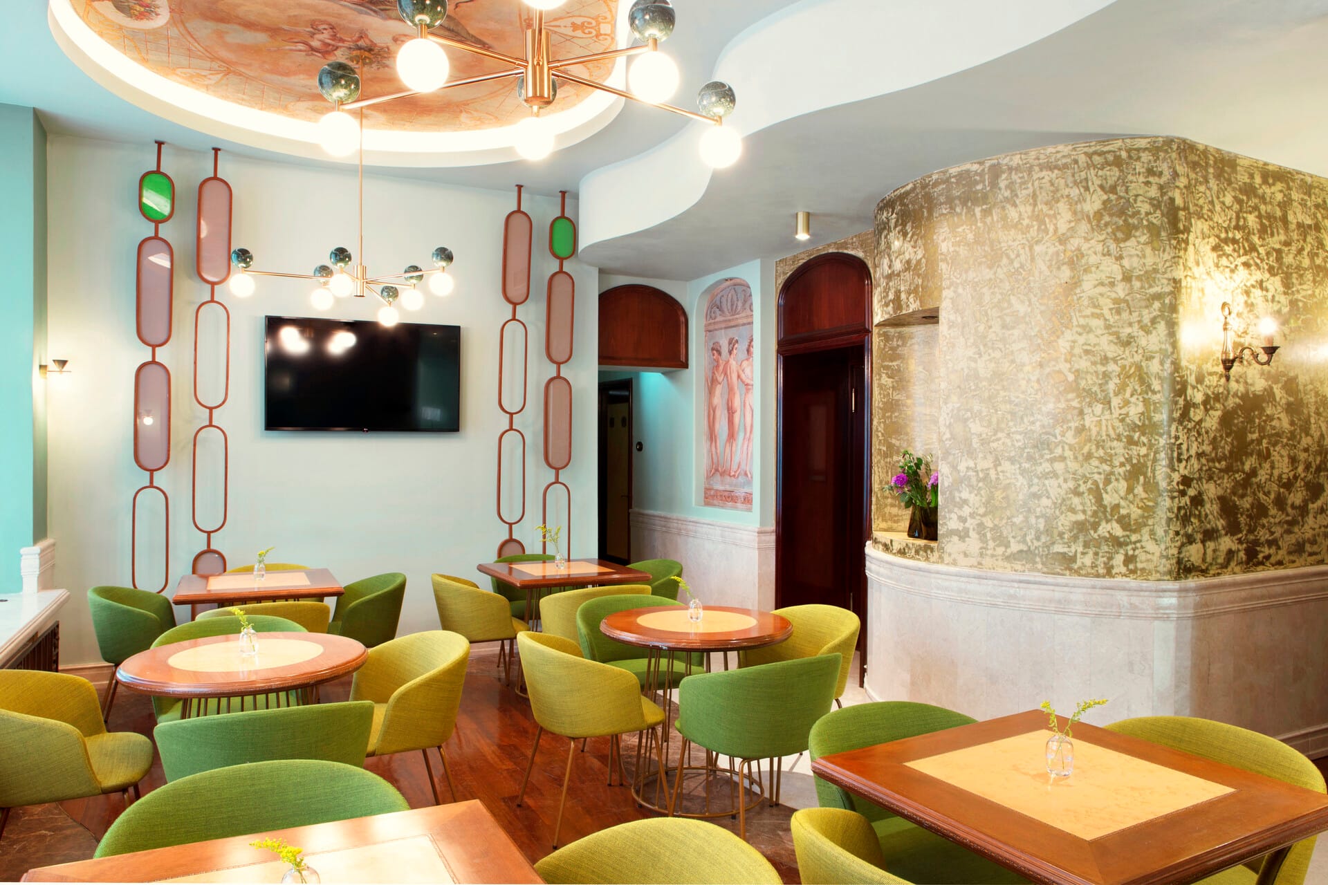 a room with green chairs and a television