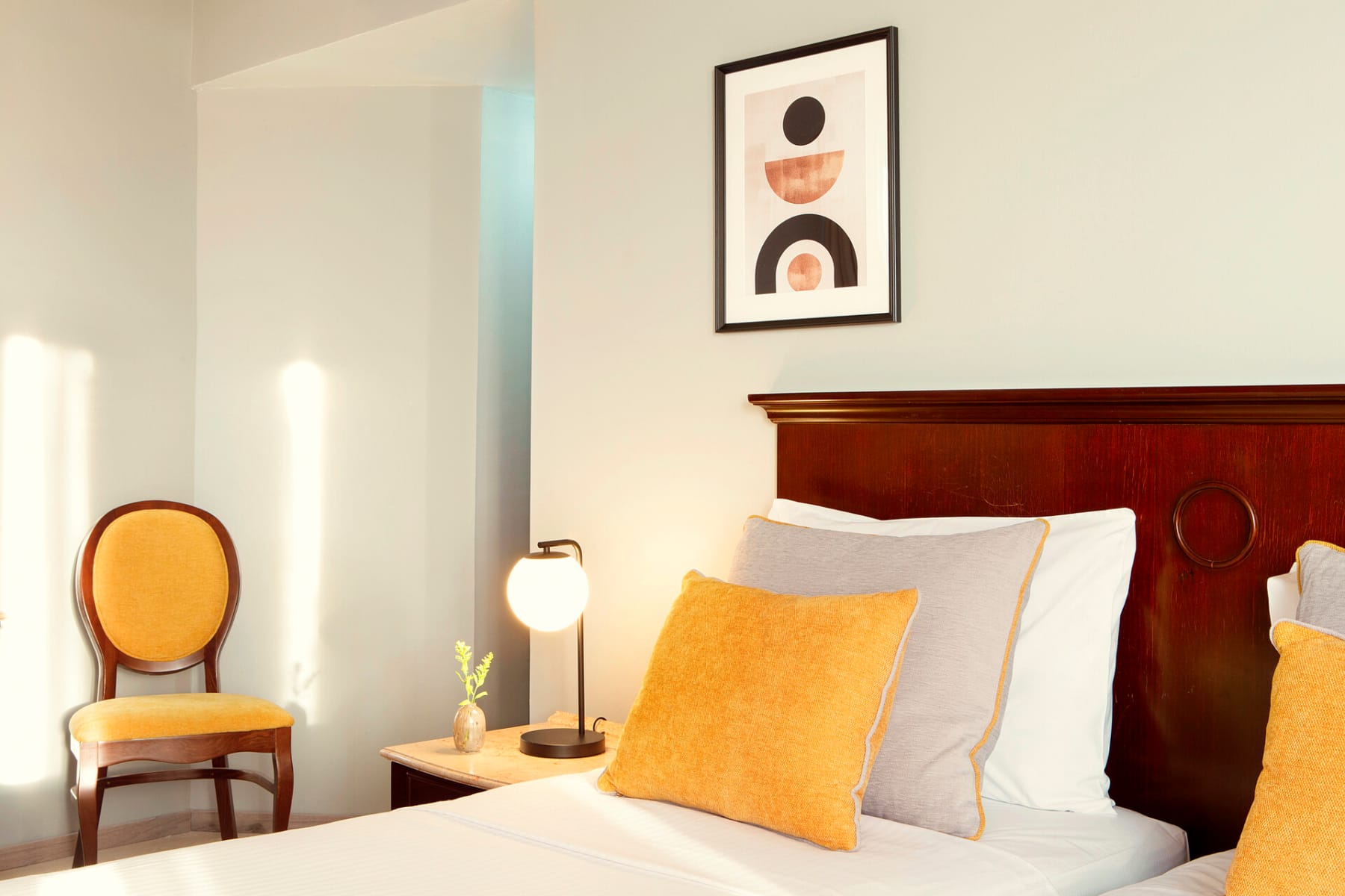 a bed with a chair and a lamp on the side