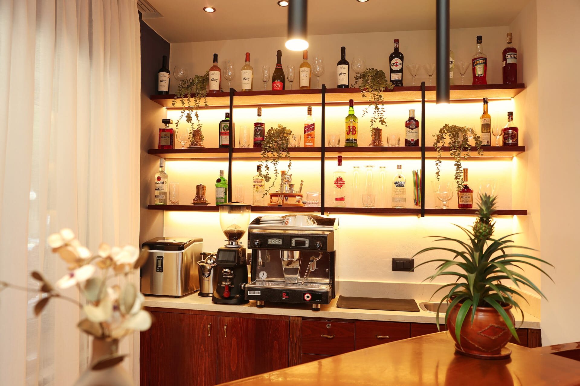 a kitchen with a shelf full of alcohol