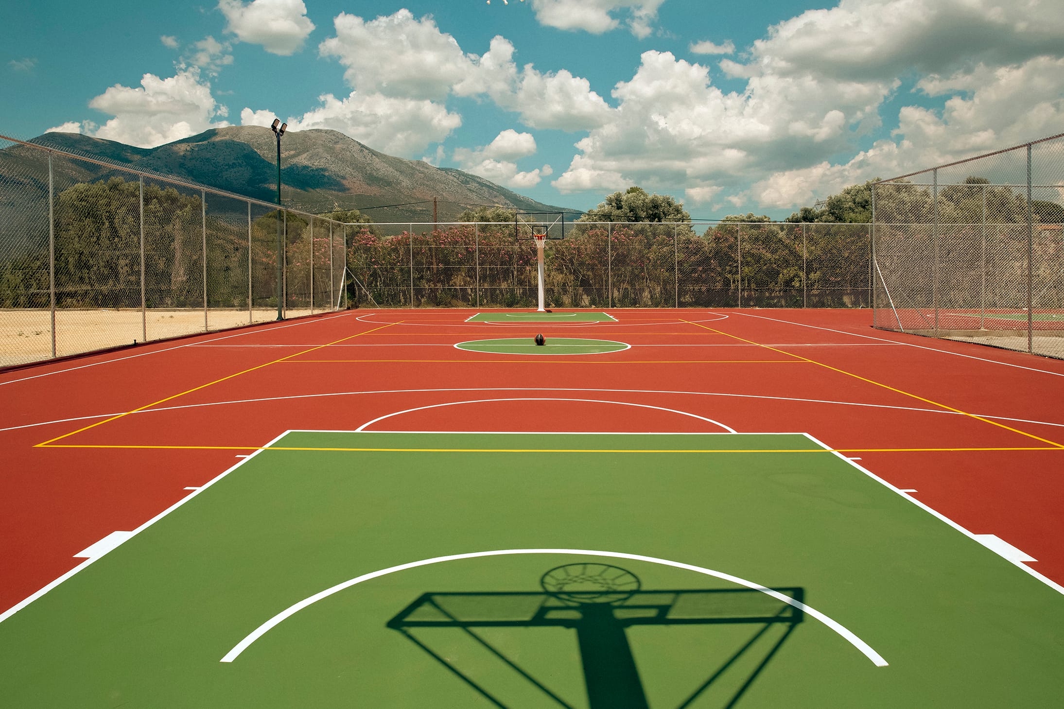 a track with a track and a field with trees and mountains in the background