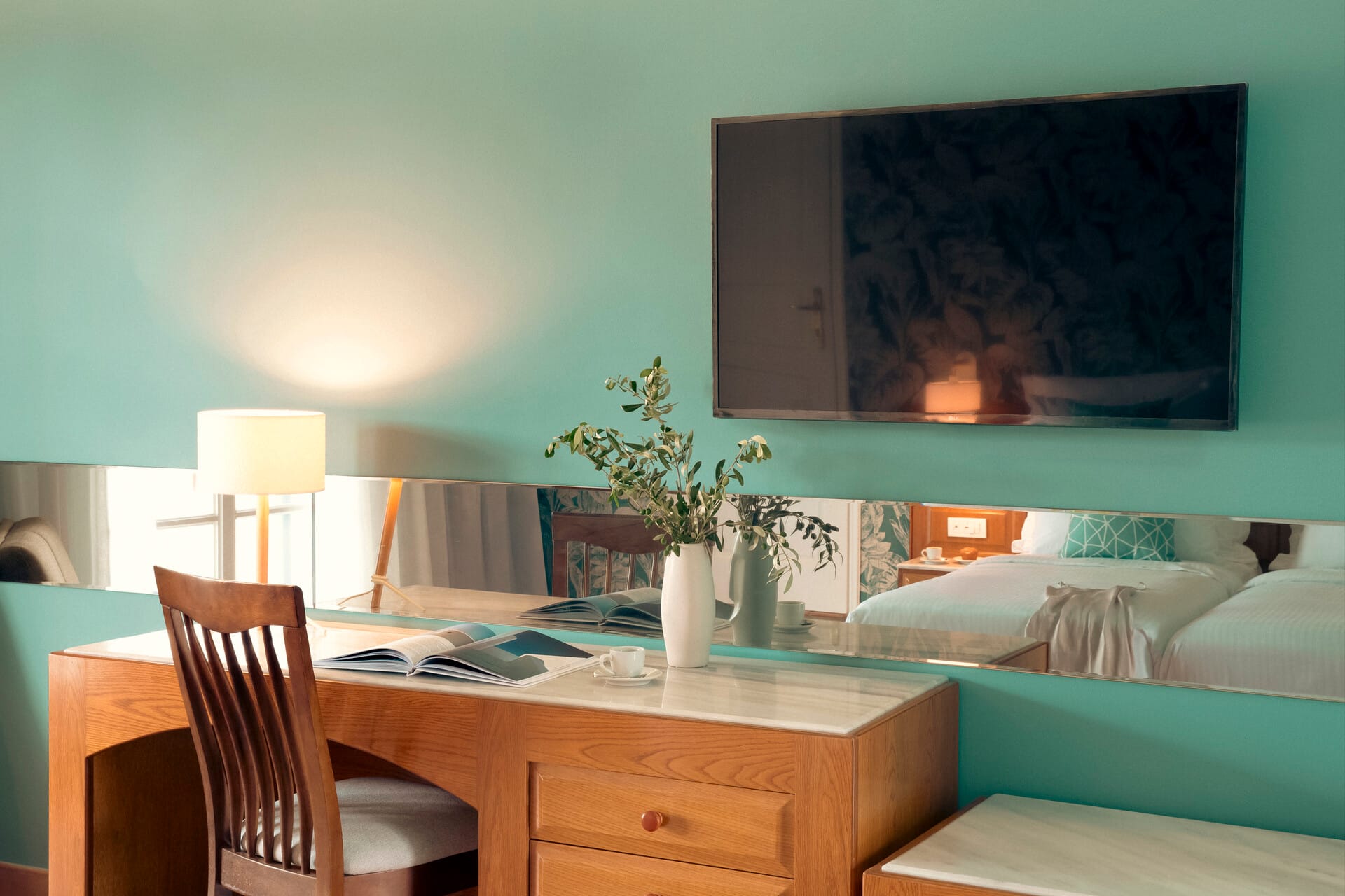 a room with a desk and a chair and a green wall